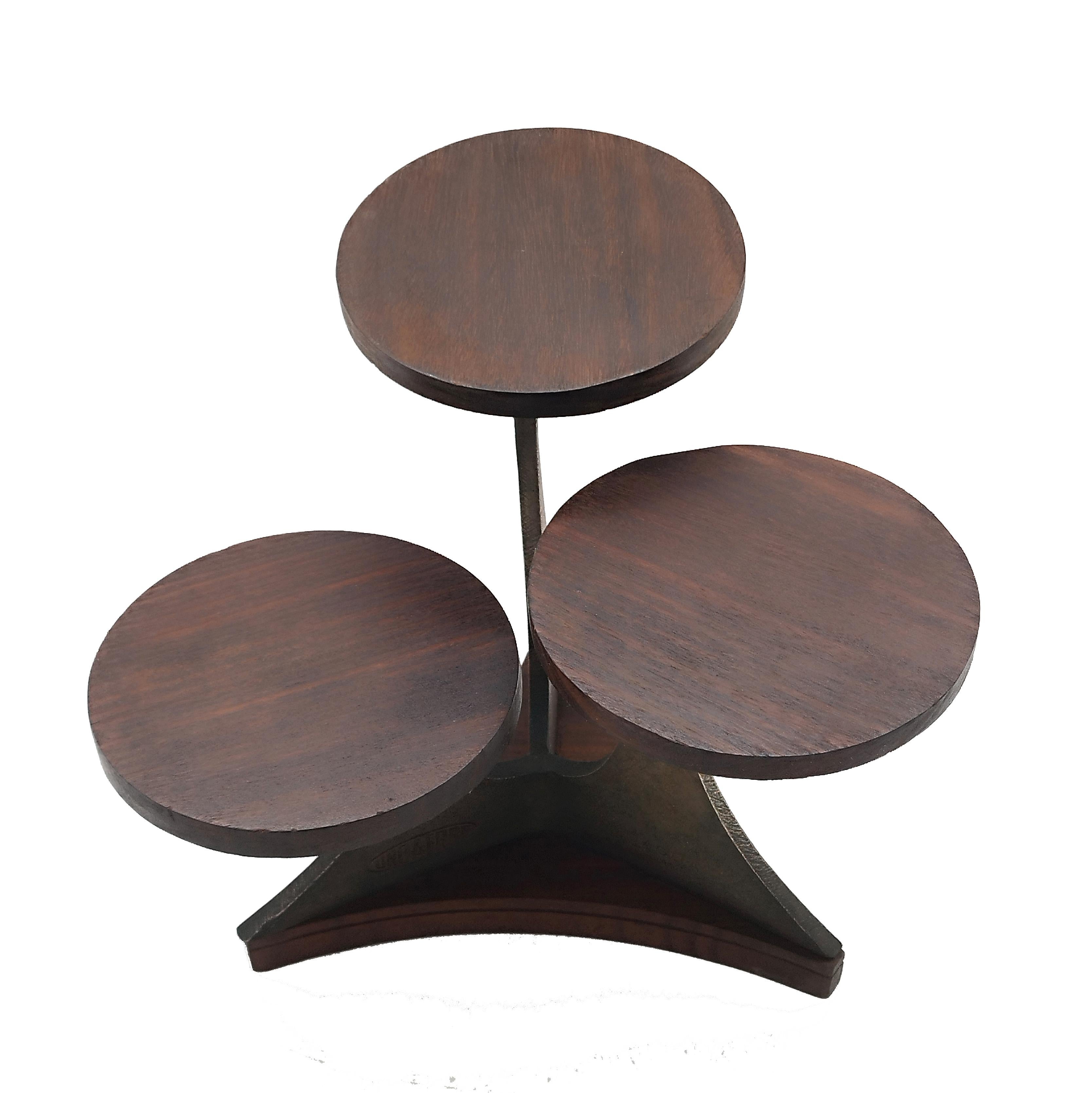 A display stand/shelf with round wooden shelves and cast brass frame, it was created to promote the UnoAErre company's Medaglia dell' Amore jewel in the 1970s