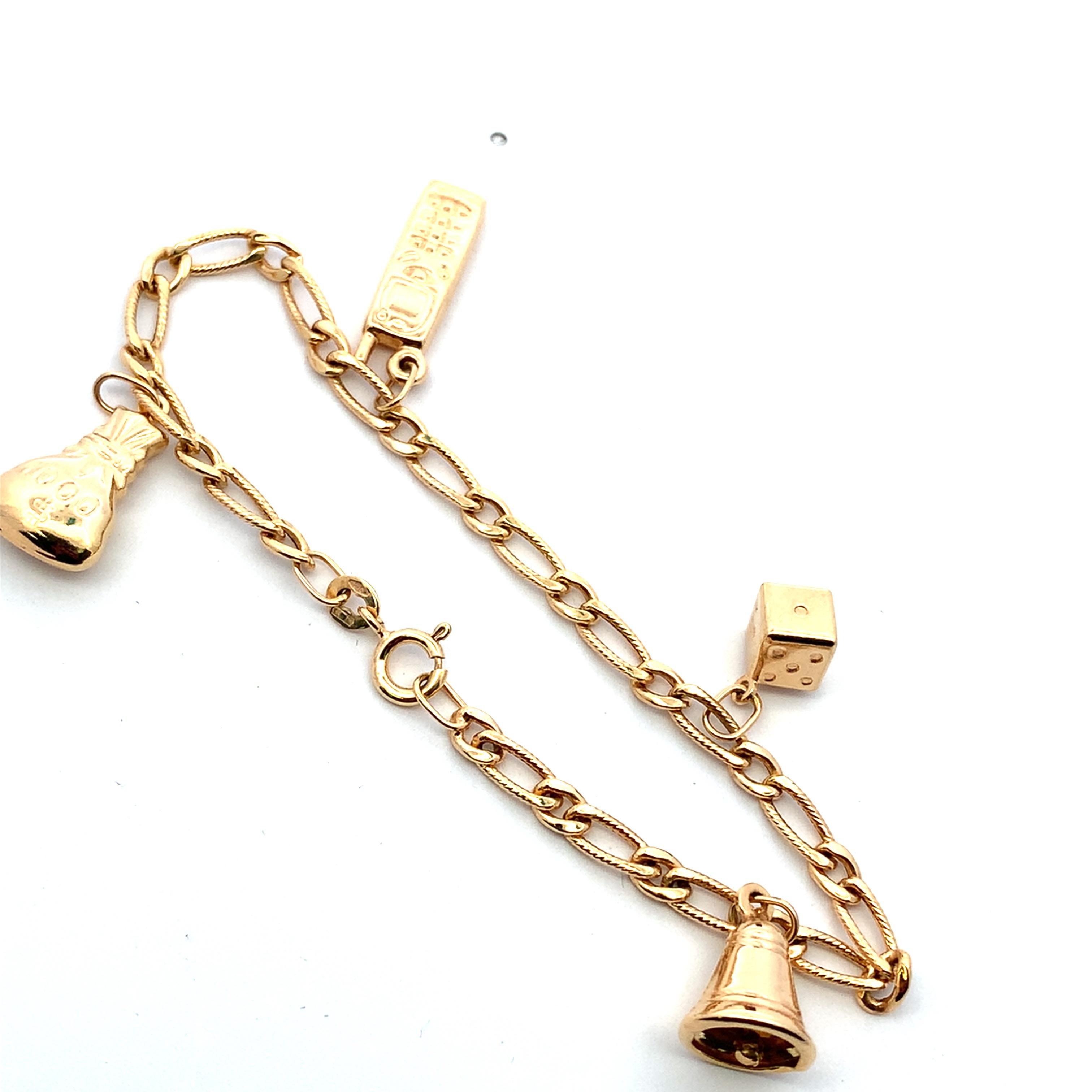 Elevate your wrist with this whimsical 9ct Unoaerre Italian yellow gold charm bracelet. Featuring playfully designed charms including a miniature phone, boxing glove, bell and dice, this bracelet exudes a sense of fun. The intricate chain work adds
