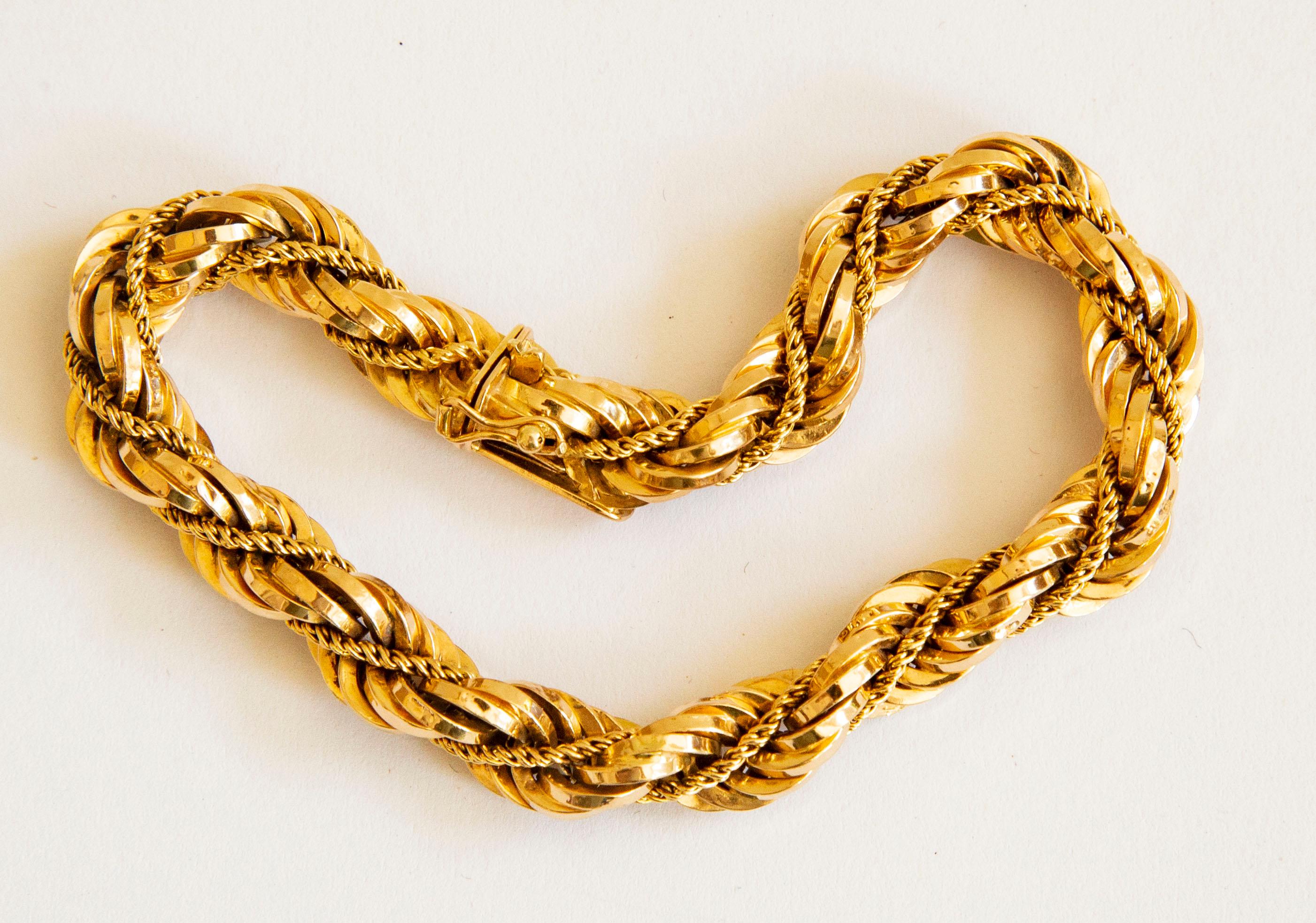 An Italian 18 karat yellow gold twist rope chain/cord bracelet manufactured by UnoAErre in Arezzo, Italy in 1970s. The bracelet features a wide twisted cord intertwined with a single and a narrow cord. The bracelet closes with a box lock with the