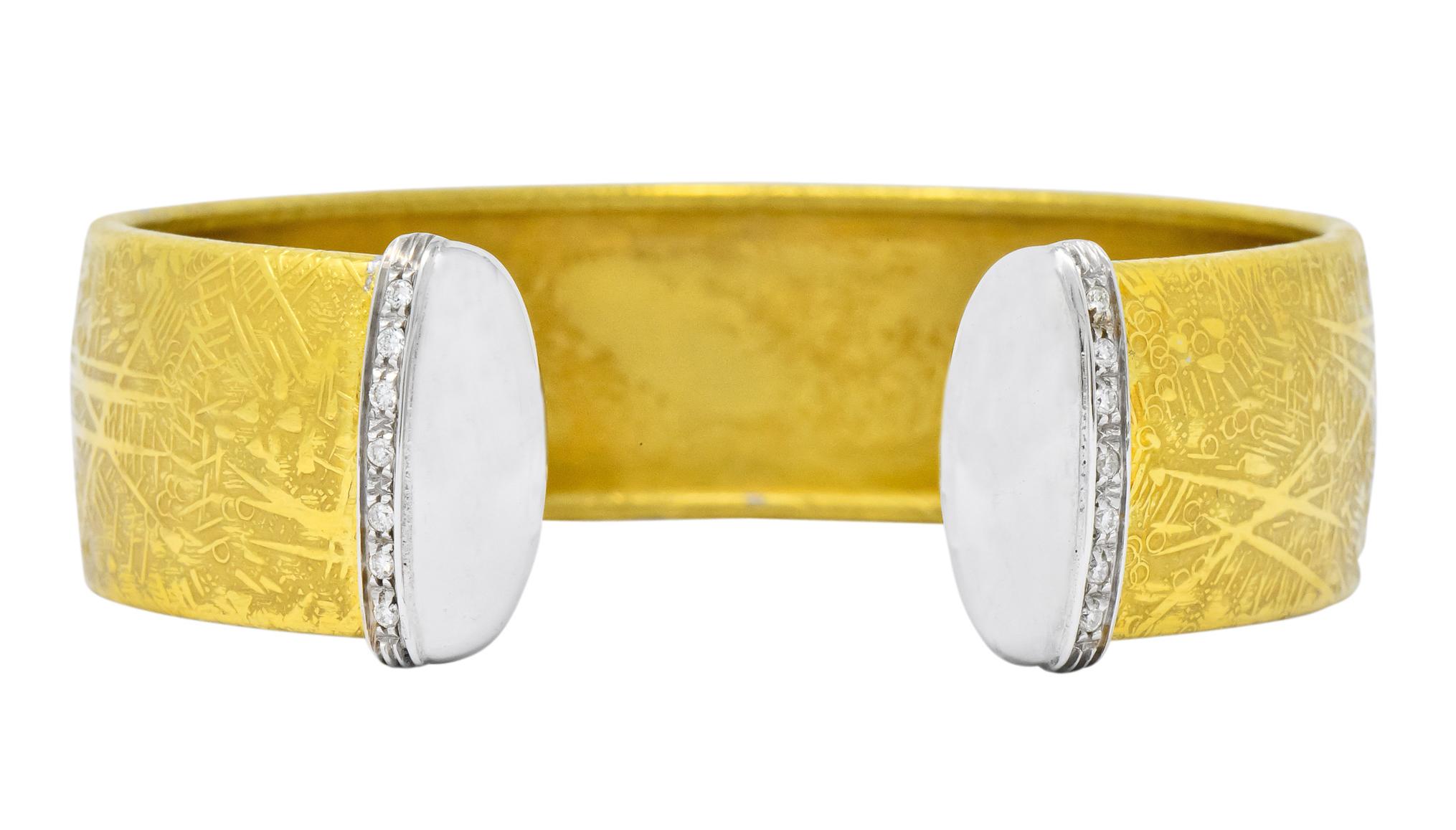 Open cuff with highly detailed and textured gold and completed with high polished white gold terminals

Accented with round brilliant cut diamonds, weighing approximately 0.25 carat total, GHI color and VS to SI clarity

Fully signed Unoaerre and