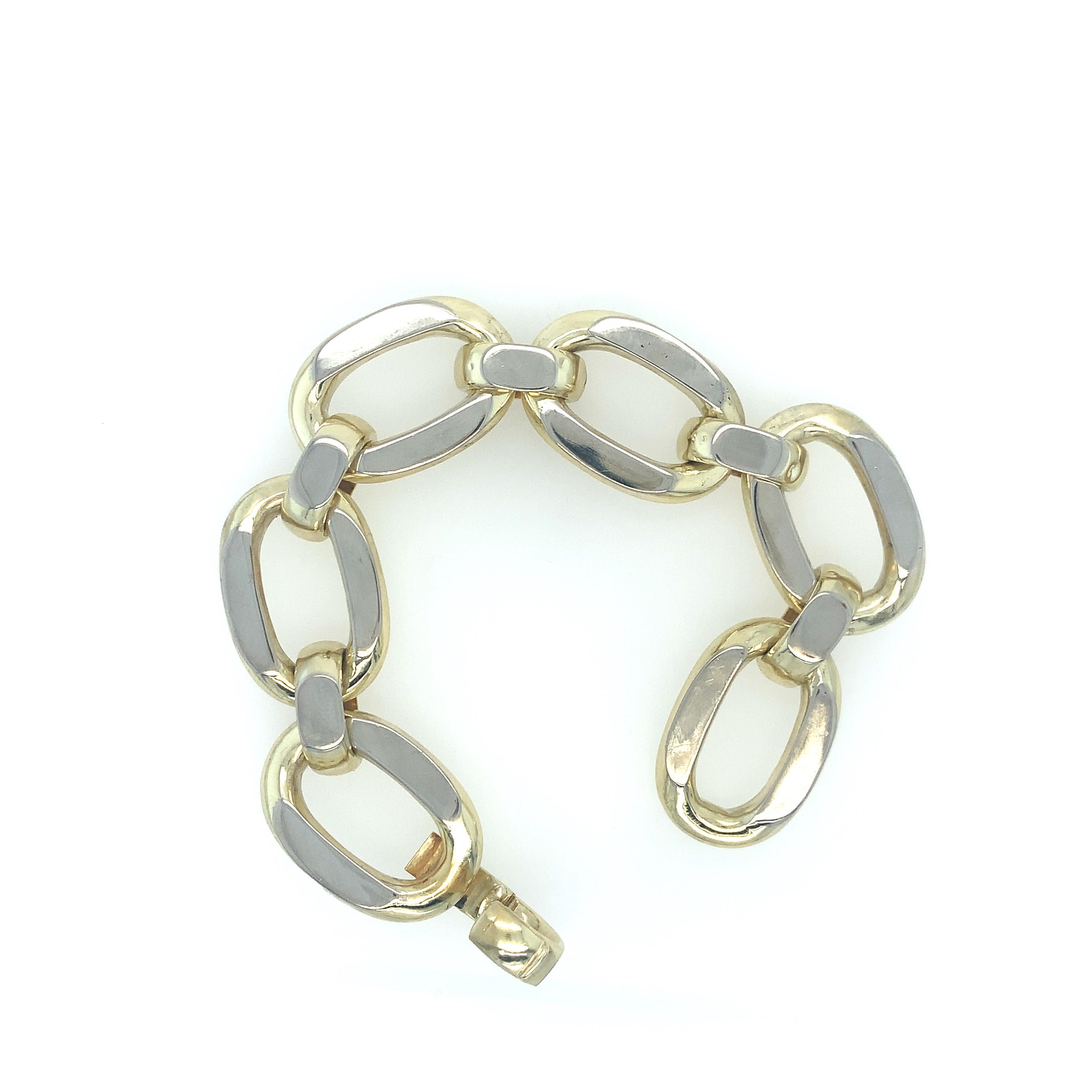 A vintage 14K two tone chain link bracelet comprised of (6) six large oval links joined with smaller domed links with flat polished surfaces. It is finished with an integrated hinged dome clasp – created by UnoAErre, an accomplished Italian jewelry