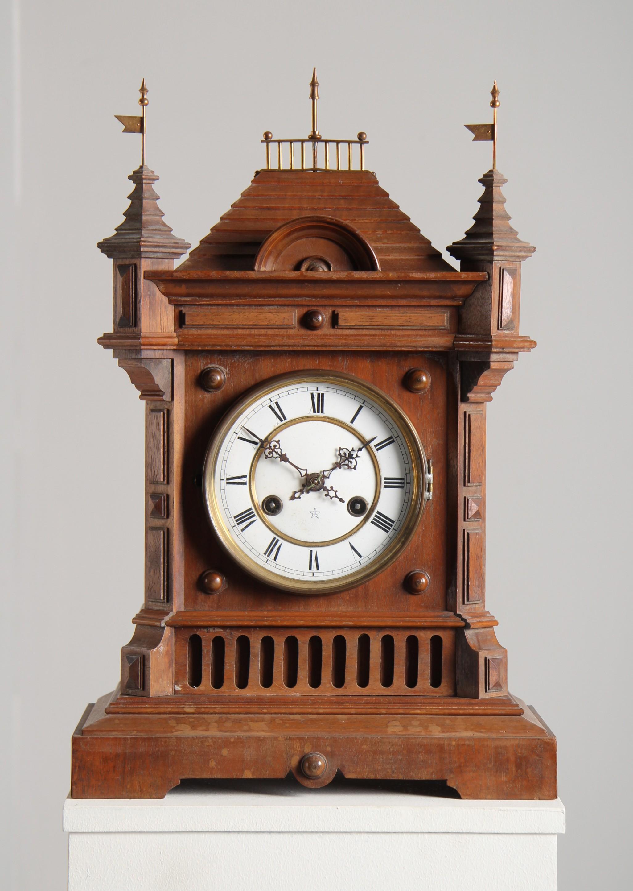 Late 19th Century German Mantel Clock. 

Walnut in shape of an old castle.

The movement needs to get overhauld. The clock is in unrestored condition.