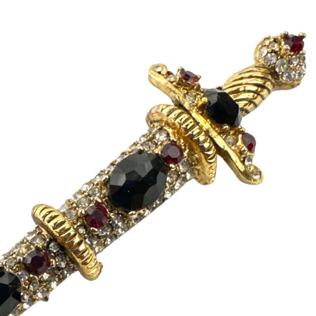 Embark on a journey of bold sophistication with this Unsigned KJL Sword Brooch Pin. Vintage allure meets daring design, making a statement that transcends time.

At an impressive length of 3.75 inches, this brooch pin commands attention, becoming a