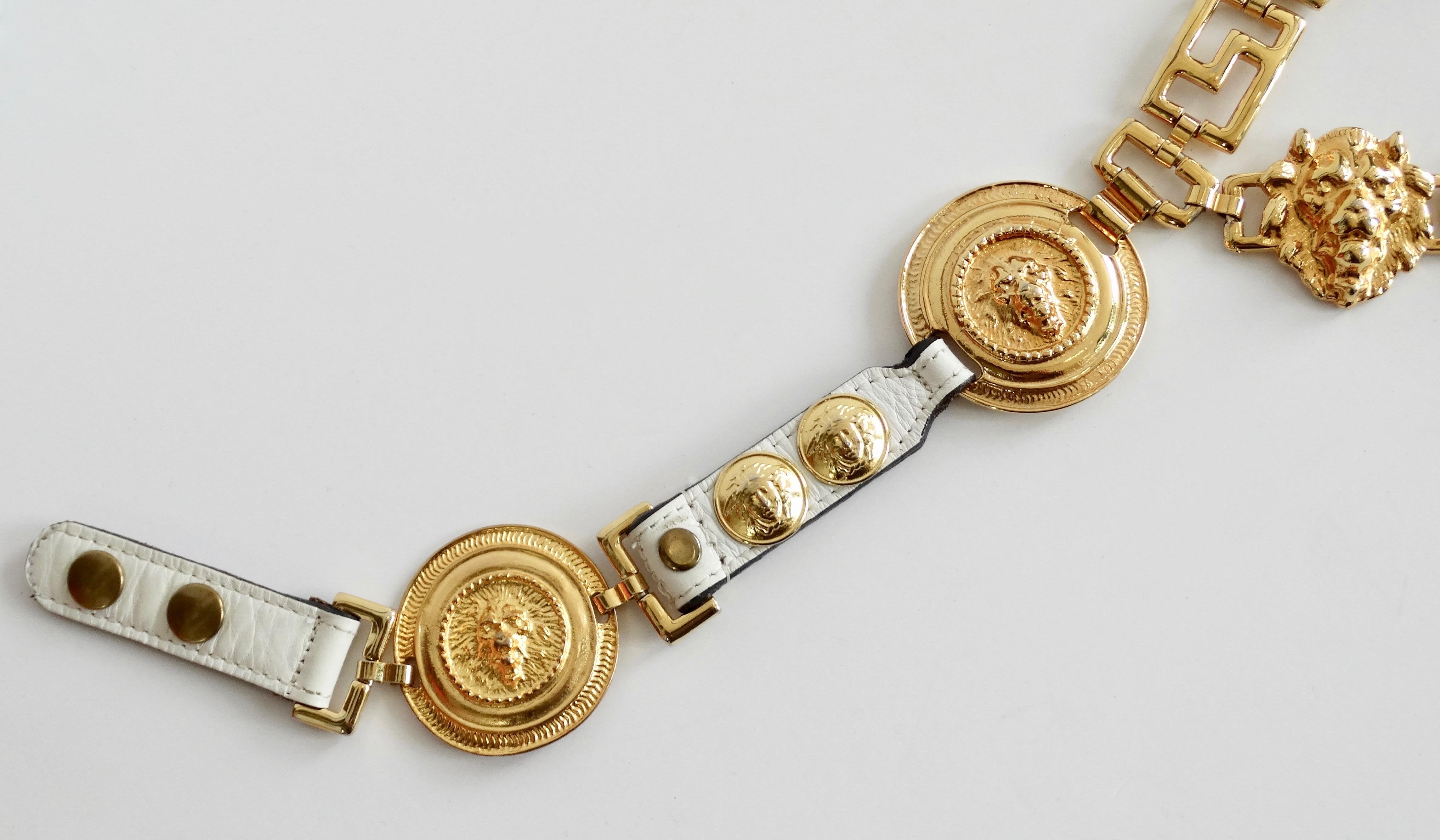 Give your outfit a whole new look with this killer unsigned Versace belt! Circa 1980s, this gold plated chain link belt features a single drop chain with a chain link tassel, white leather accents, the Versace Greek key and three sculpted lion