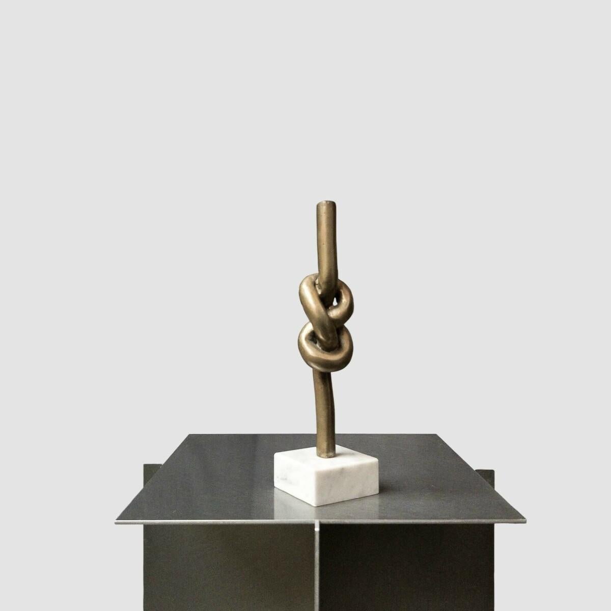 Pequeño nudo de bronce realizado por el artista belga Mart de Houwer. A lo largo de su carrera artística, De Houwer exploró un tema: la línea. A finales de la década de 1980 creó una serie de esculturas de nudos en distintos materiales, explorando