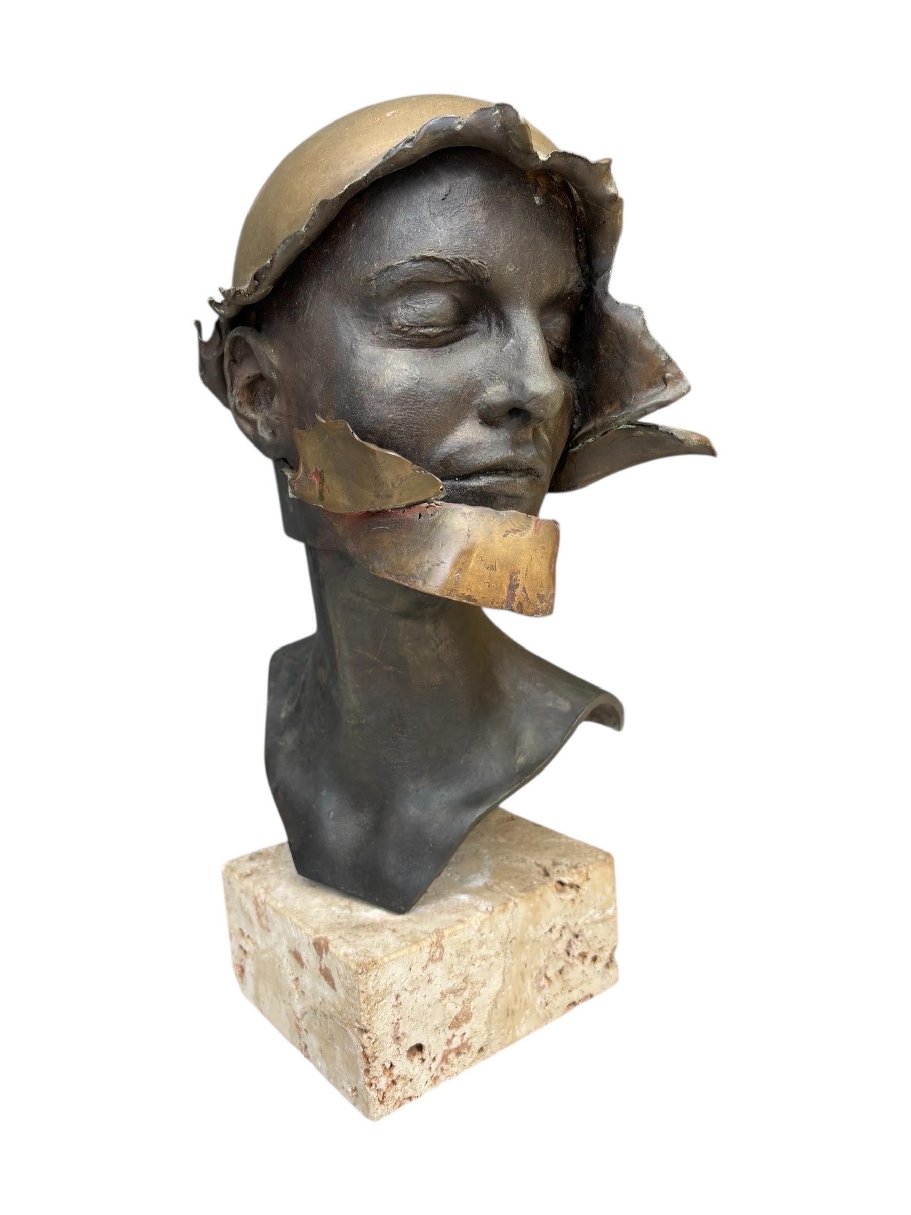 Una escultura busto sin título del artista William Ludwig. La cabeza de bronce fundido está girada 45 grados hacia la izquierda, y tiene una expresión pacífica con los ojos cerrados. Un casco de capas con acabado dorado parece desplegarse alrededor