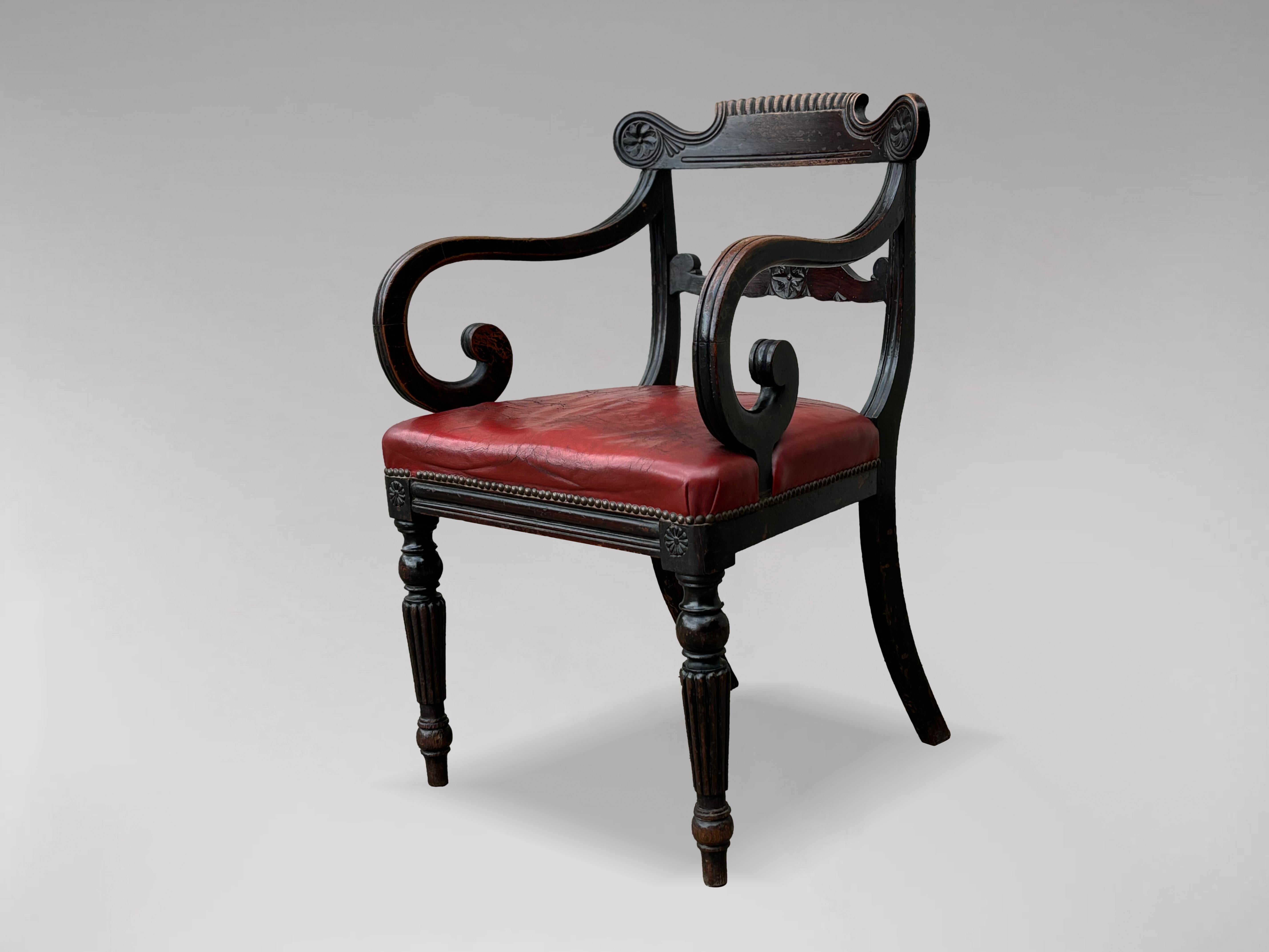 An untouched early 19th-century Georgian mahogany desk armchair. This chair features a pierced arched top rail carved with acanthus leaves and scrolls, while the bar backs showcase shaped splats adorned with beautiful hand-carved decoration. The