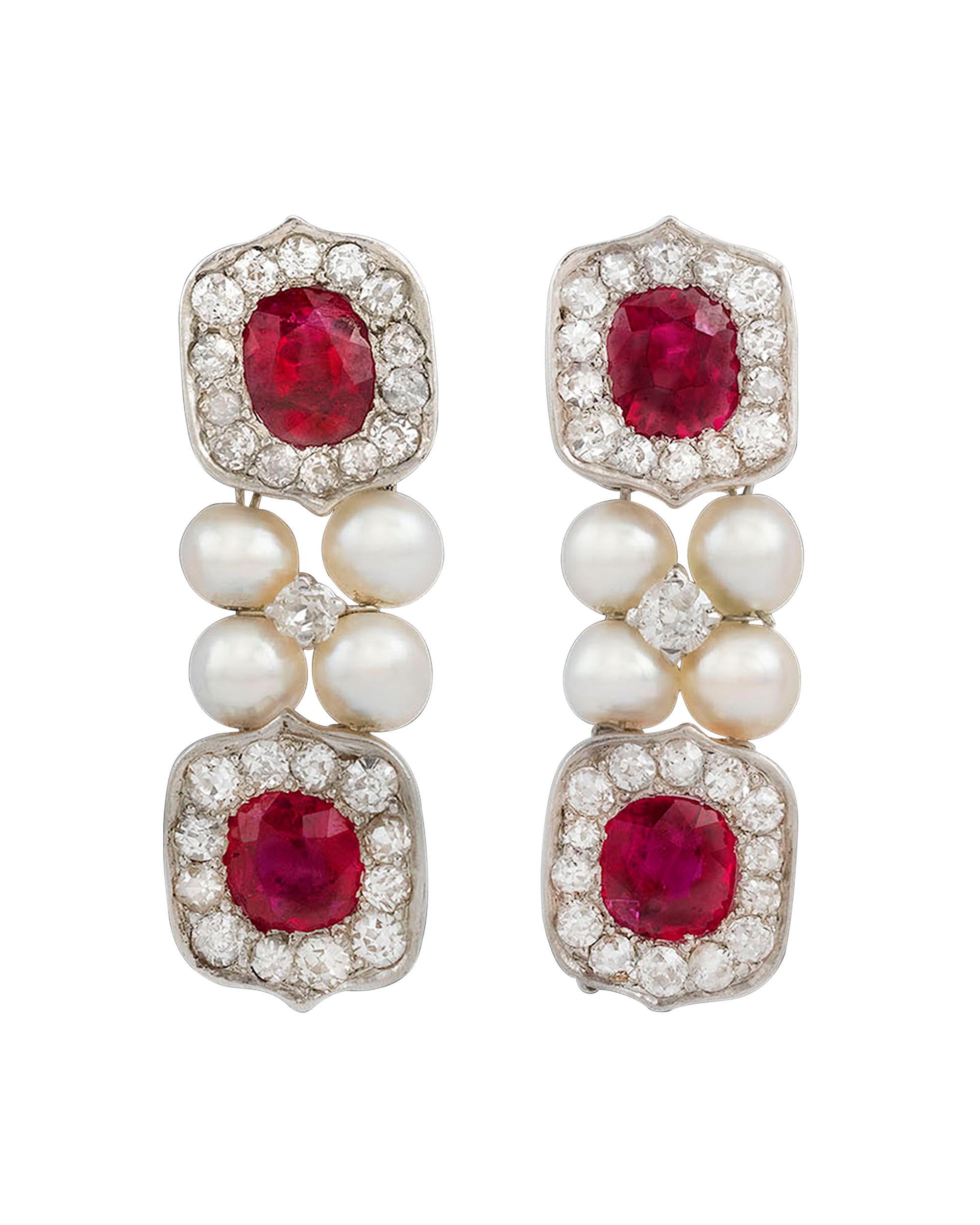 Four brilliant untreated Burma rubies, weighing approximately 2.32 total carats, dazzle in these drop earrings. Creamy white pearls and an estimated .60 carats of shimmering white diamonds accentuate these crimson jewels. The rubies are certified by