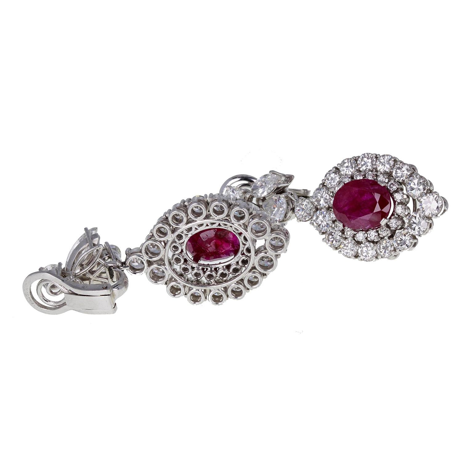 Two perfectly matched, untreated Burma rubies, each of approximately 3.40 carats, surrounded by a double row of brilliant-cut diamonds, suspended from a cluster of marquise-cut diamonds. Clip fittings for unpierced ears. Please view the video to
