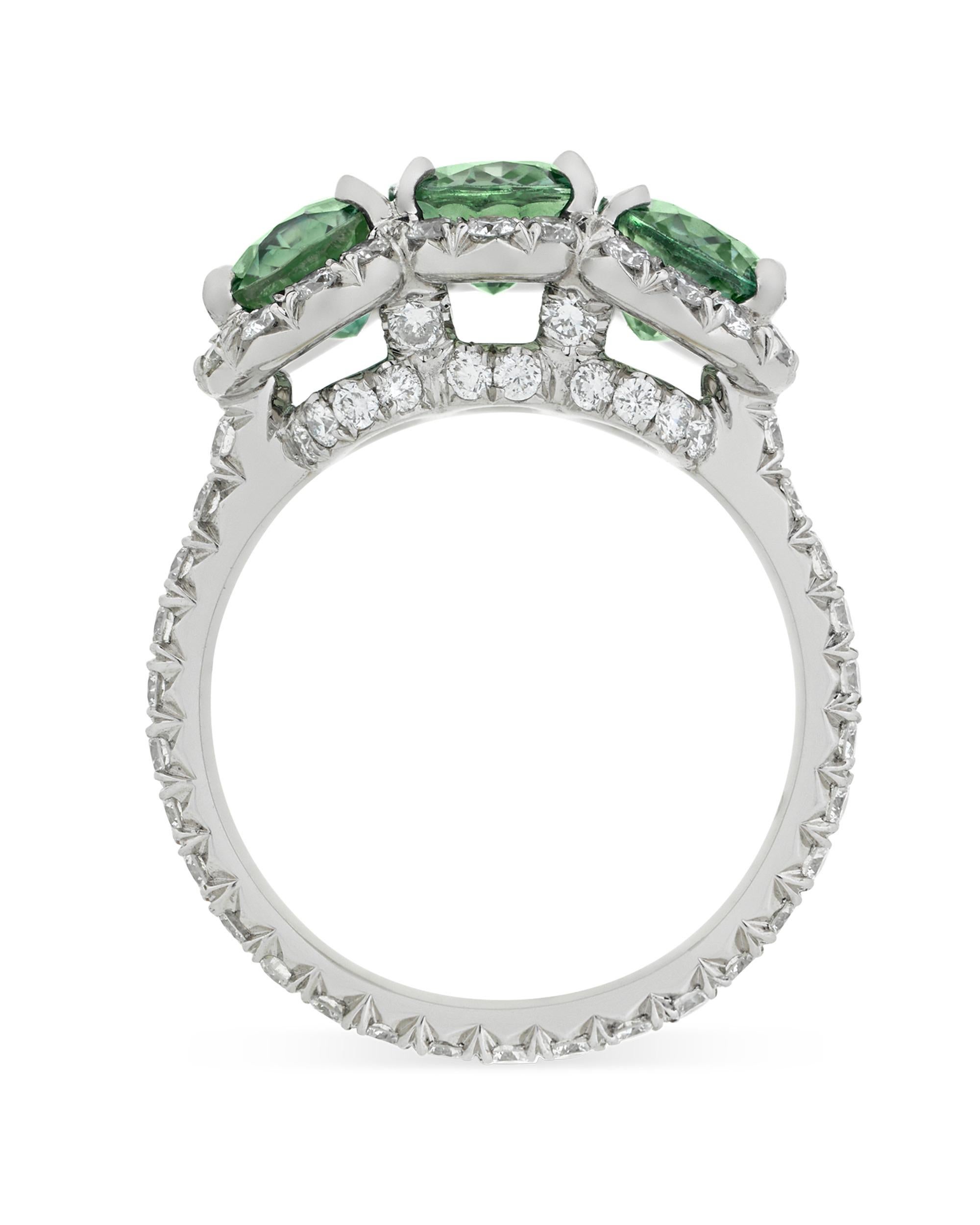 Three brilliant, untreated green sapphires weighing 4.69 combined carats showcase their dazzling color in this classic ring. Certified by C. Dunaigre to be 