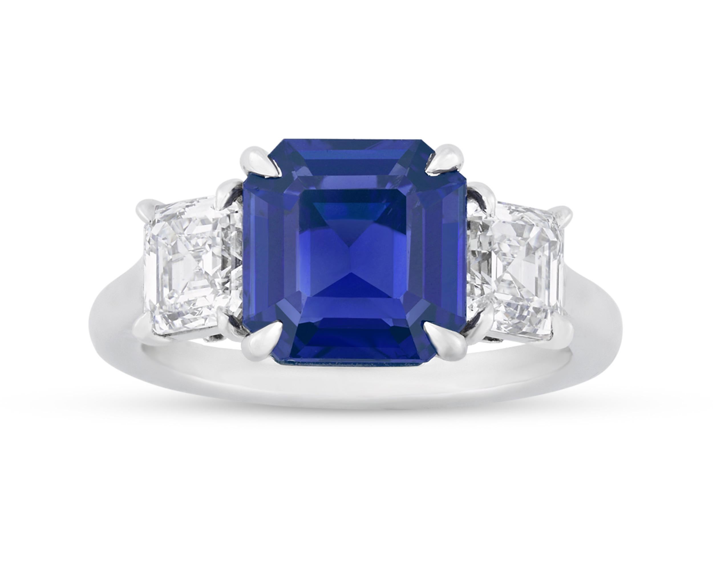 This remarkable octagonal step-cut Kashmir sapphire achieves the deep, velvety blue hue so prized in these gems. Weighing 3.32 carats, the stone's vibrant color is completely natural and perfectly complemented by two emerald-cut white diamonds