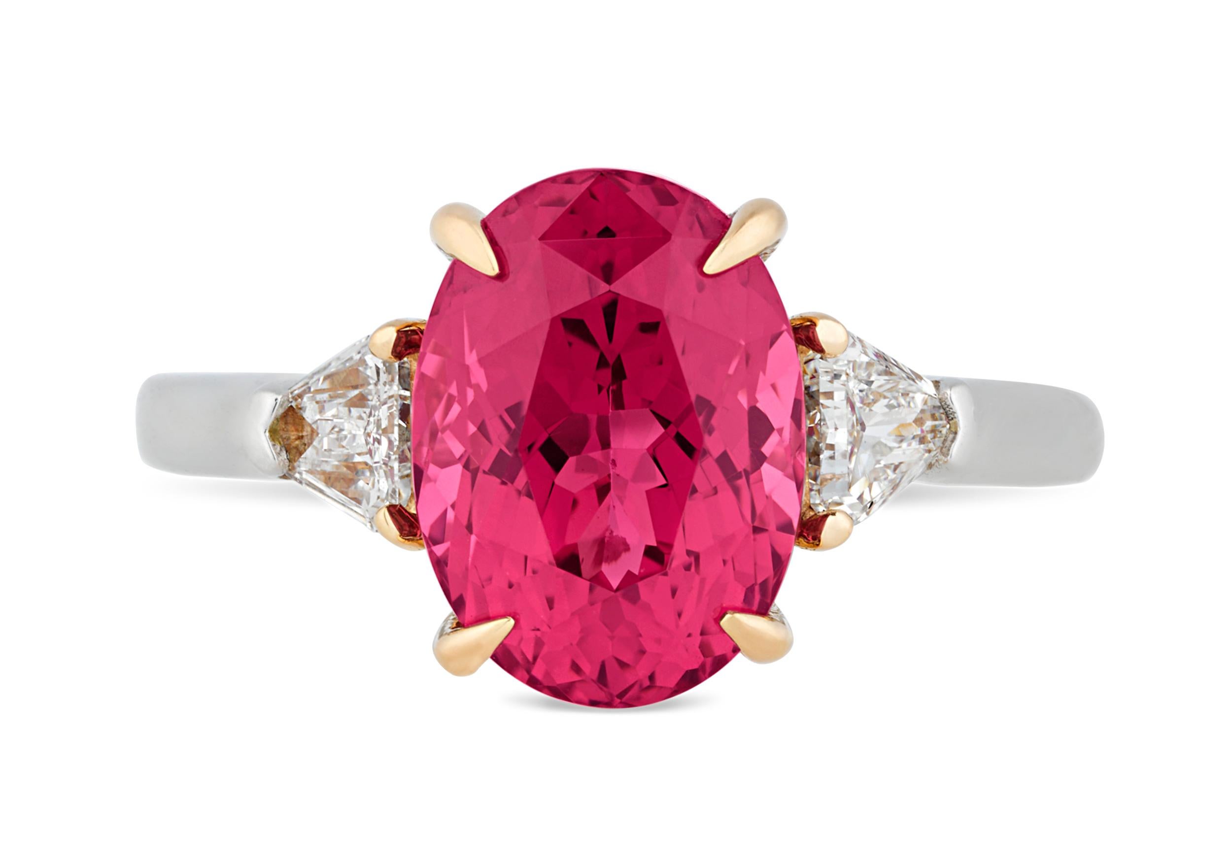 A sparkling red spinel captivates the eye in this ring. Exhibiting a deep crimson color, this 4.07-carat jewel is set in platinum and 18K rose gold between two shield-cut diamonds totaling 0.39 carat. Though often mistaken for rubies or sapphires,