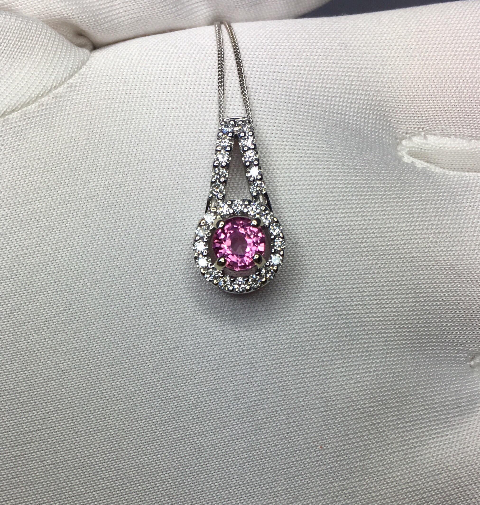 Stunning natural vivid pink sapphire set in a fine 18k white gold diamond cluster pendant. 

0.62 carat centre sapphire (5mm) with stunning pink colour and excellent clarity. Top grade stone. 

This stone also has an excellent quality cut which