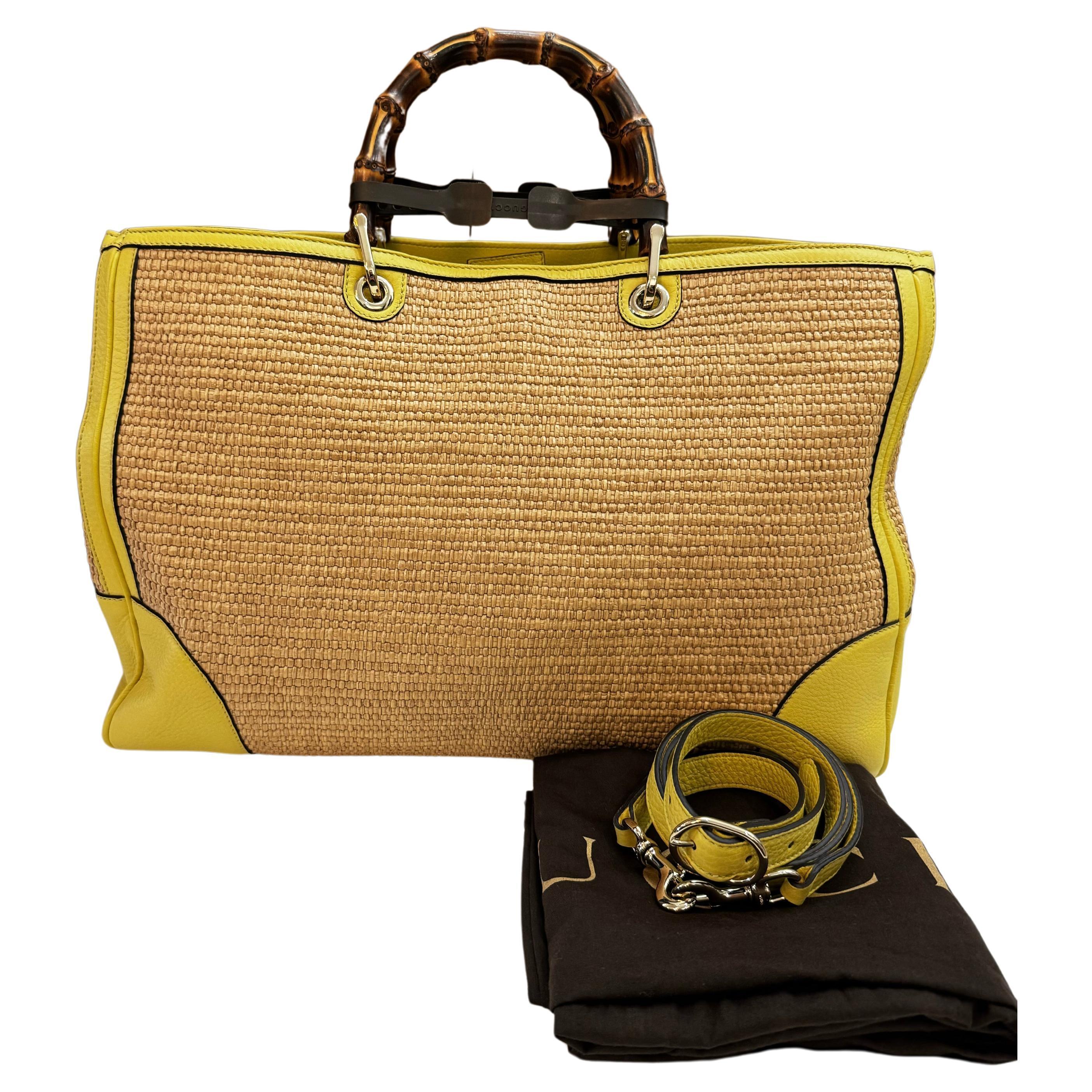 This large GUCCI raffia bamboo tote bag is crafted of woven straw in its natural color with calfskin leather in yellow featuring gold toned hardware and sturdy bamboo handles. Wide top magnetic closures open to a striped canvas interior featuring