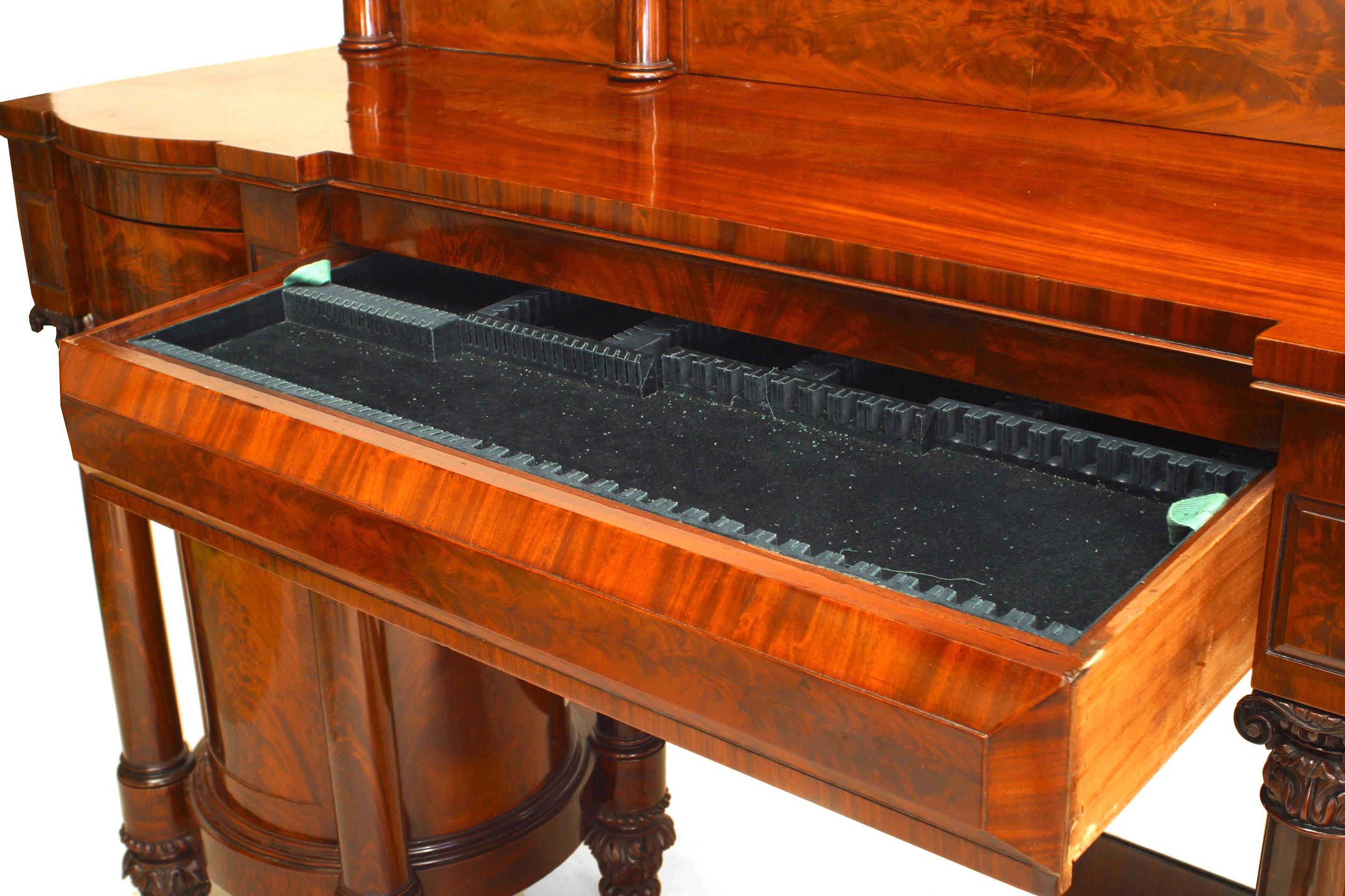 American Empire mahogany sideboard with two pedestal cabinets and 4 carved column supports centering a lower mirror under 3 drawers with a back splash. (Attributed to DUNCAN PHYFE)
