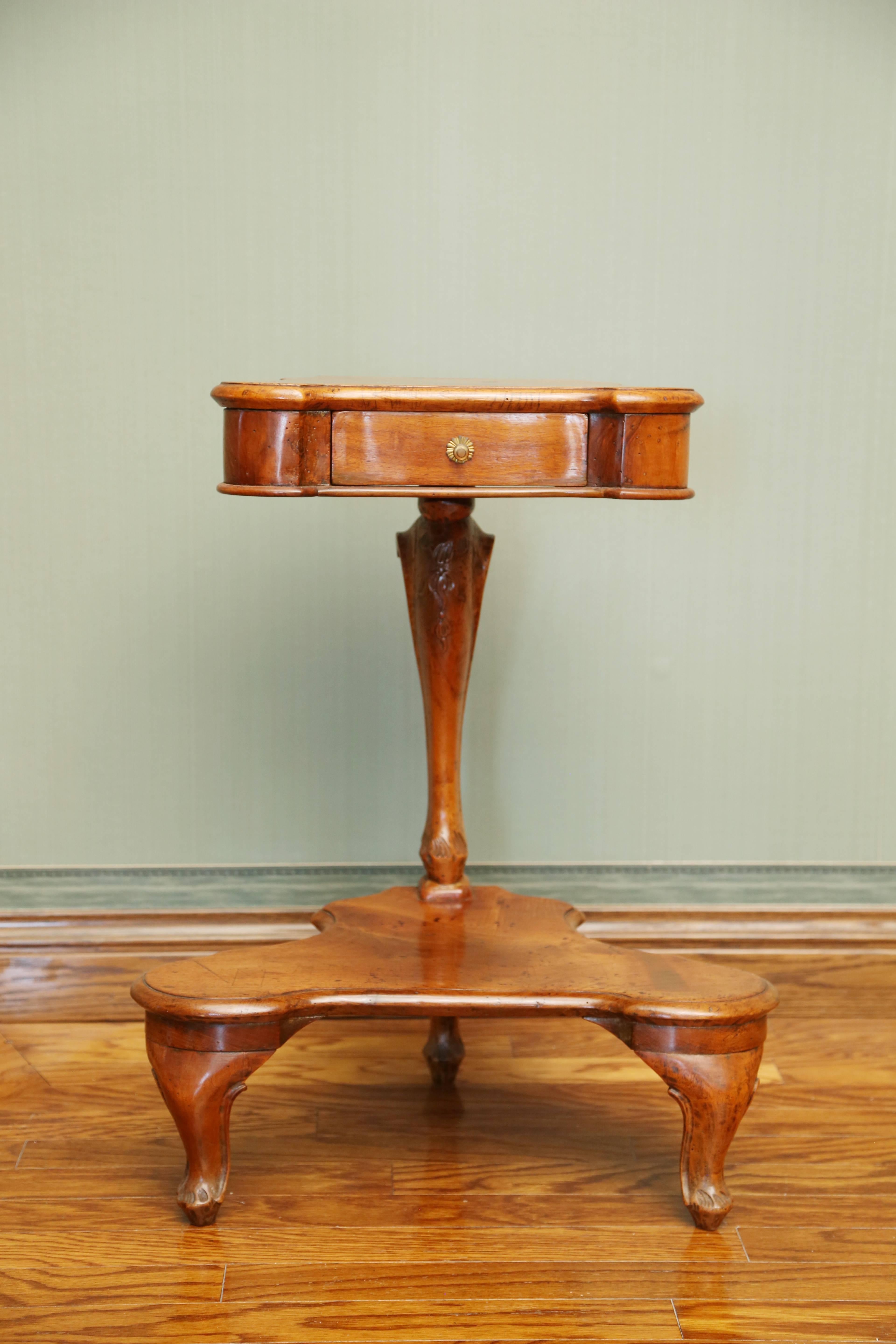 The shaped top fitted with a frieze drawer above a foliate-carved arching support on a shaped platform stretcher; raised on carved cabriole feet.