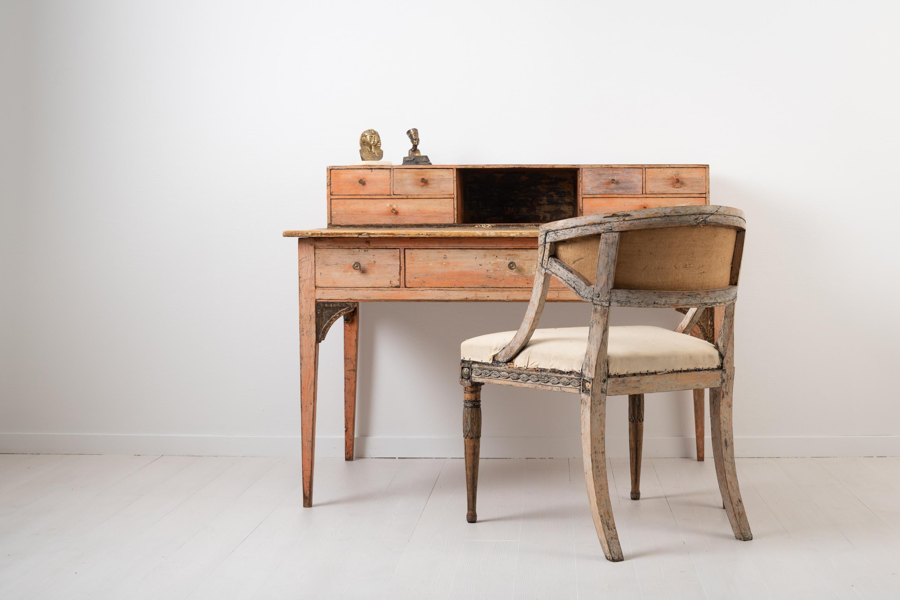 Unusual neoclassical writing table with original salmon pink paint. The paint has naturally become distressed over time giving the table an authentic patina. The desk has a top gallery with drawers on each side. The gallery or additional upper part