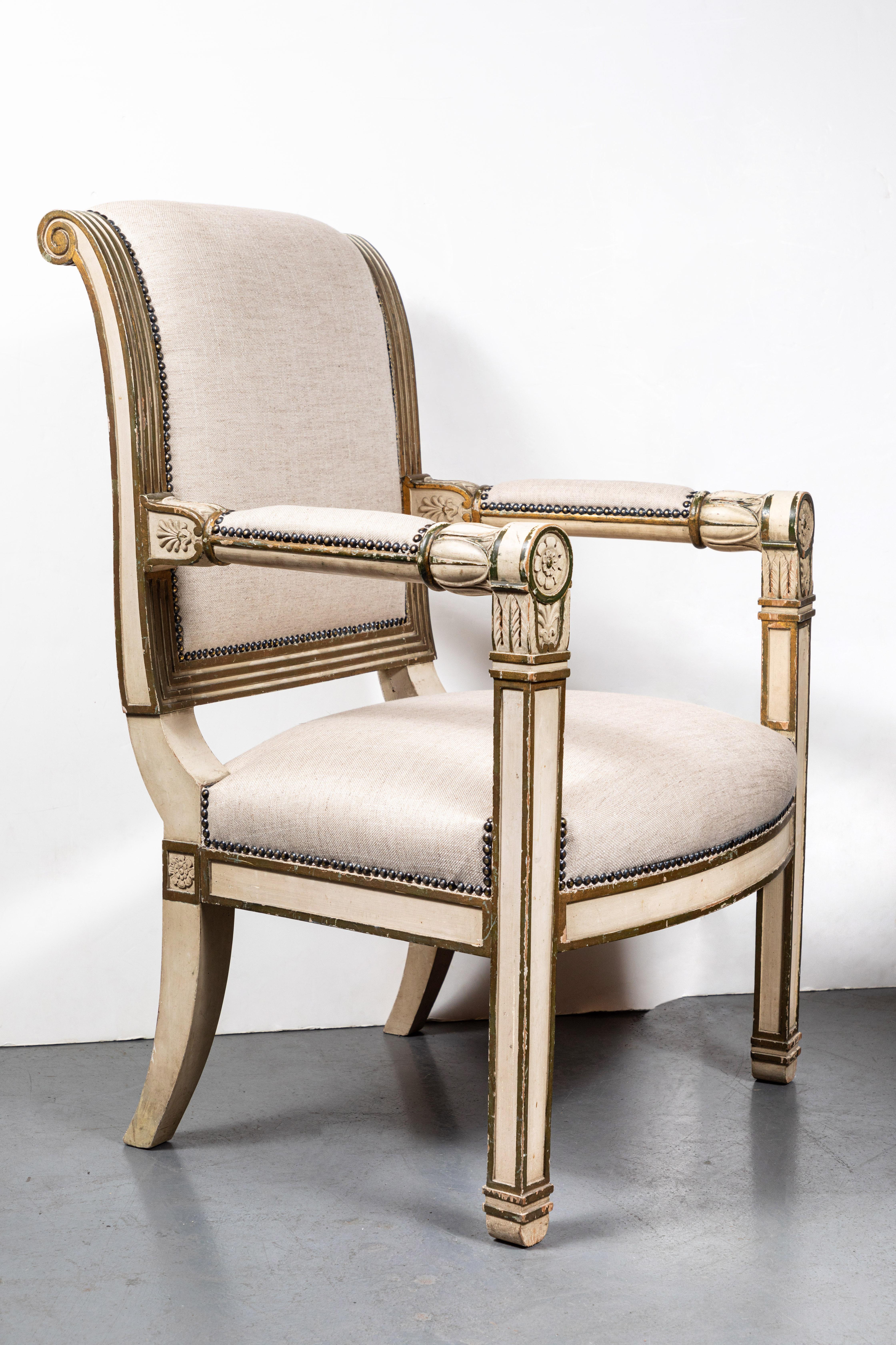 Beautifully proportioned, crème painted and parcel-gilt, neoclassical style, Italian armchair. The arms featuring petals and foliate, relief carved embellishments. The back terminates in graceful semi-scroll. Upholstered in contemporary linen.