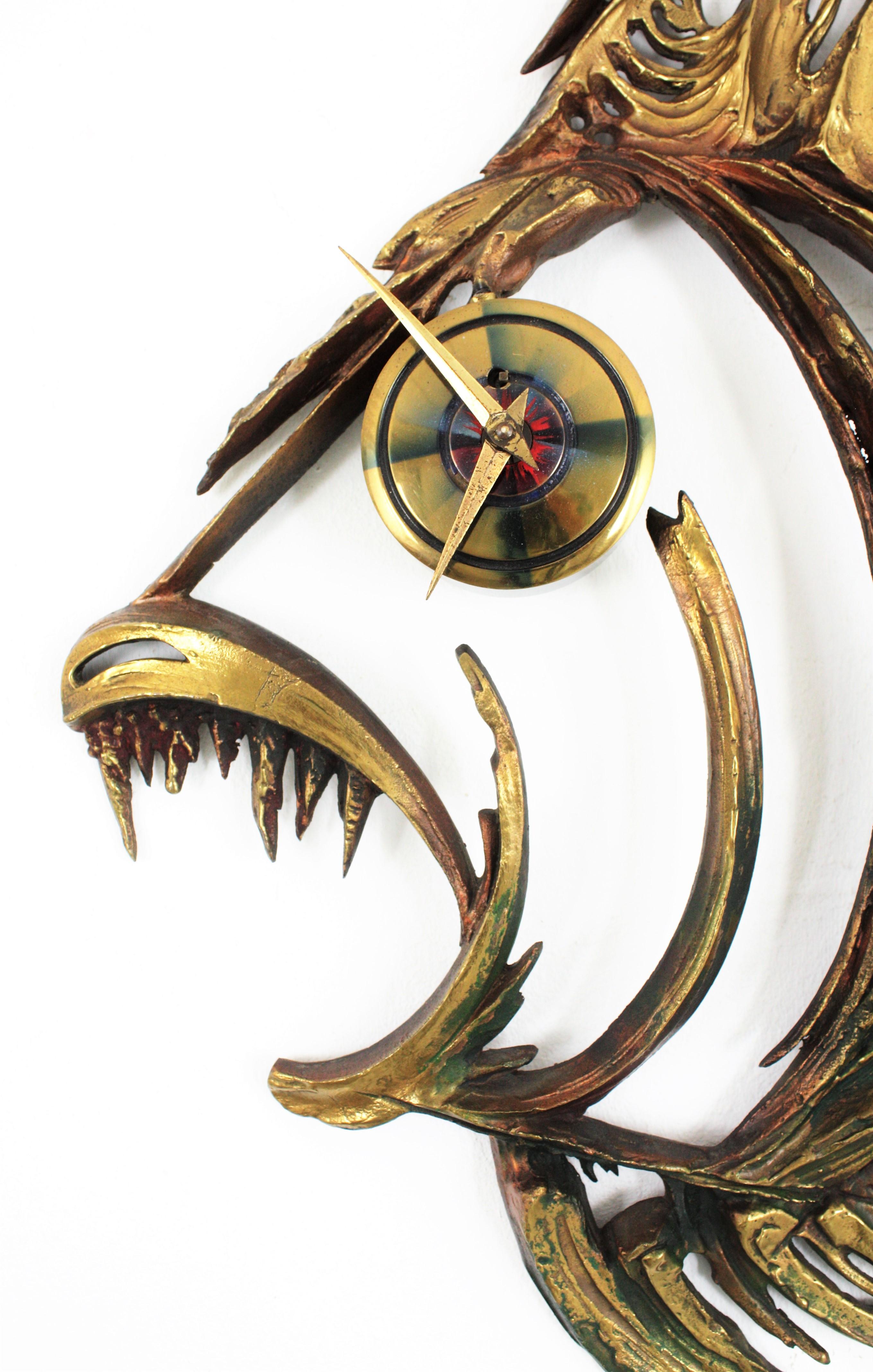 Impressive bronze and brass piranha fish wall mounted sculpture with a clock placed as eye. France, 1950s.
Finely executed, It has some red and green accents to highlight the patina of the bronze work. German clock machine. 
Signed J C. at the front