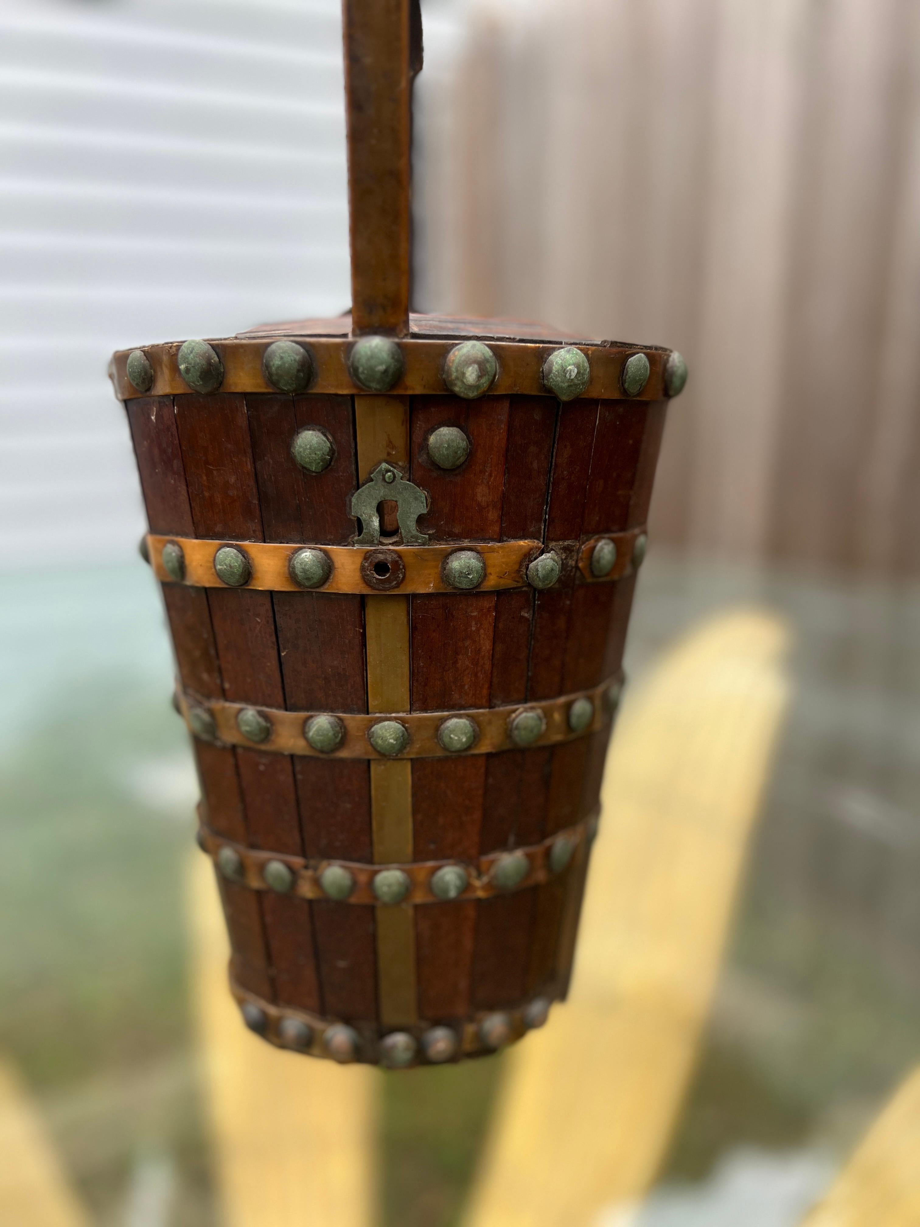 This unique 19th-century basket combines Dutch craftsmanship with Anglo-Indian stylistic influences, resulting in a truly distinctive piece. The box features paneling across the main body, nail heads across the surface, a sturdy handle strapped to