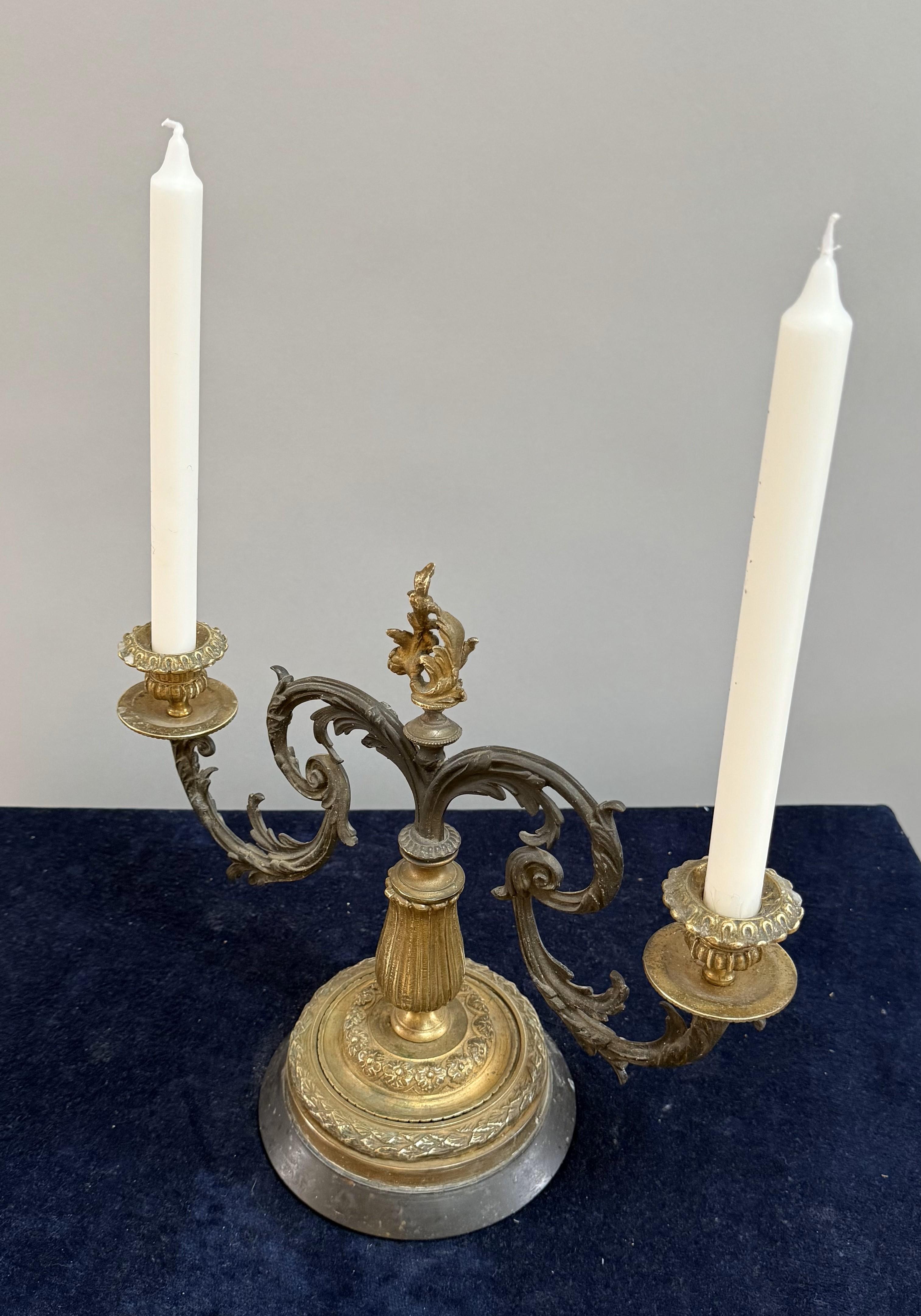 En métal foncé patiné avec des montures en bronze doré et deux bras de bougie. Fabriqué en France vers 1860.

De tout temps, les candélabres ont été un symbole de sophistication et de grandeur. Utilisé dans les cours royales, les cathédrales et les
