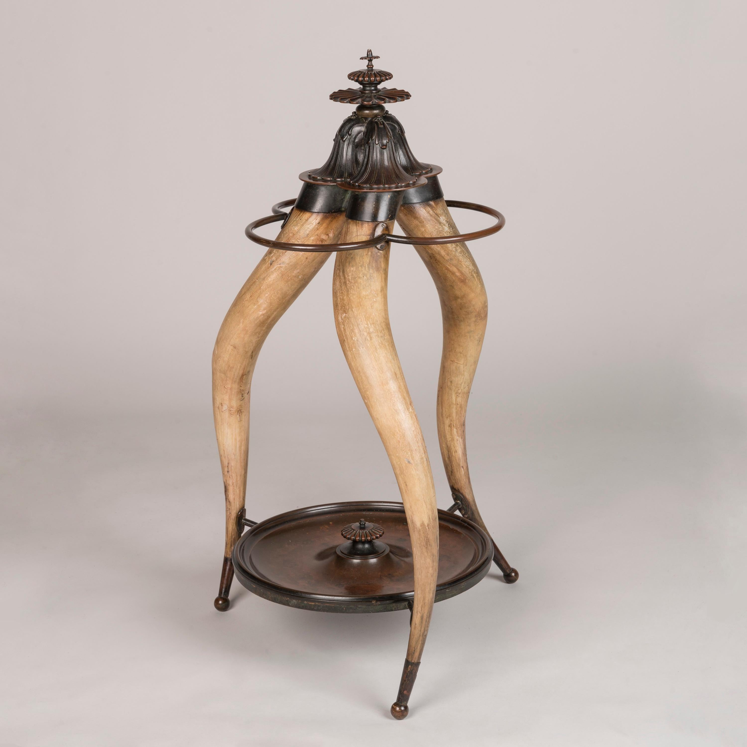 A Striking 19th Century Longhorn Stick Stand

A unique umbrella and walking stick stand, the tripod design formed from three elongated, curved legs made from animal horn, their natural beige colour enhanced by the patinated bronze fittings,