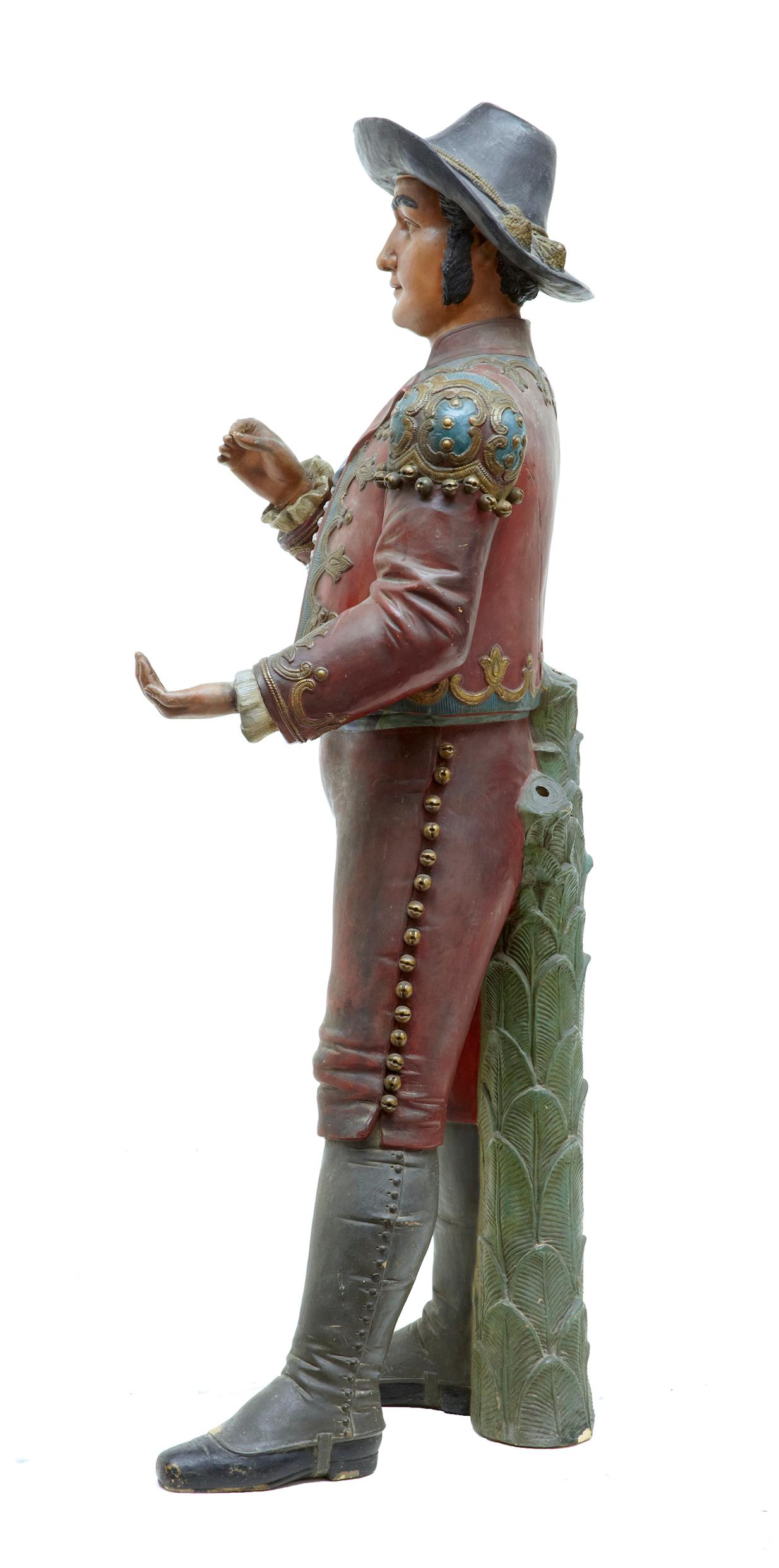 Rare and unusual Spanish figure, circa 1890. Hand painted and wearing Spanish costume. Figure supported by a cast palm tree base with 3 deep holes, for holding possibly 3 real palm branches. Restoration to wrist on 1 hand and fingers on the other.