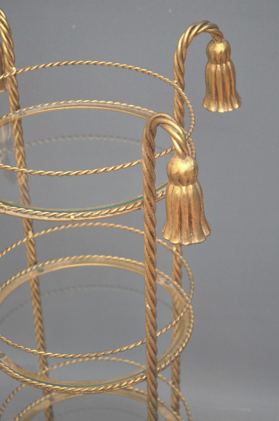 Sn3068, very unusual 3-tier gilded stand, having cord shaped supports with tassels to top and 3 glazed shelves. All in wonderful condition, ready to place at home, circa 1920-1940 .
Measures: Height 32