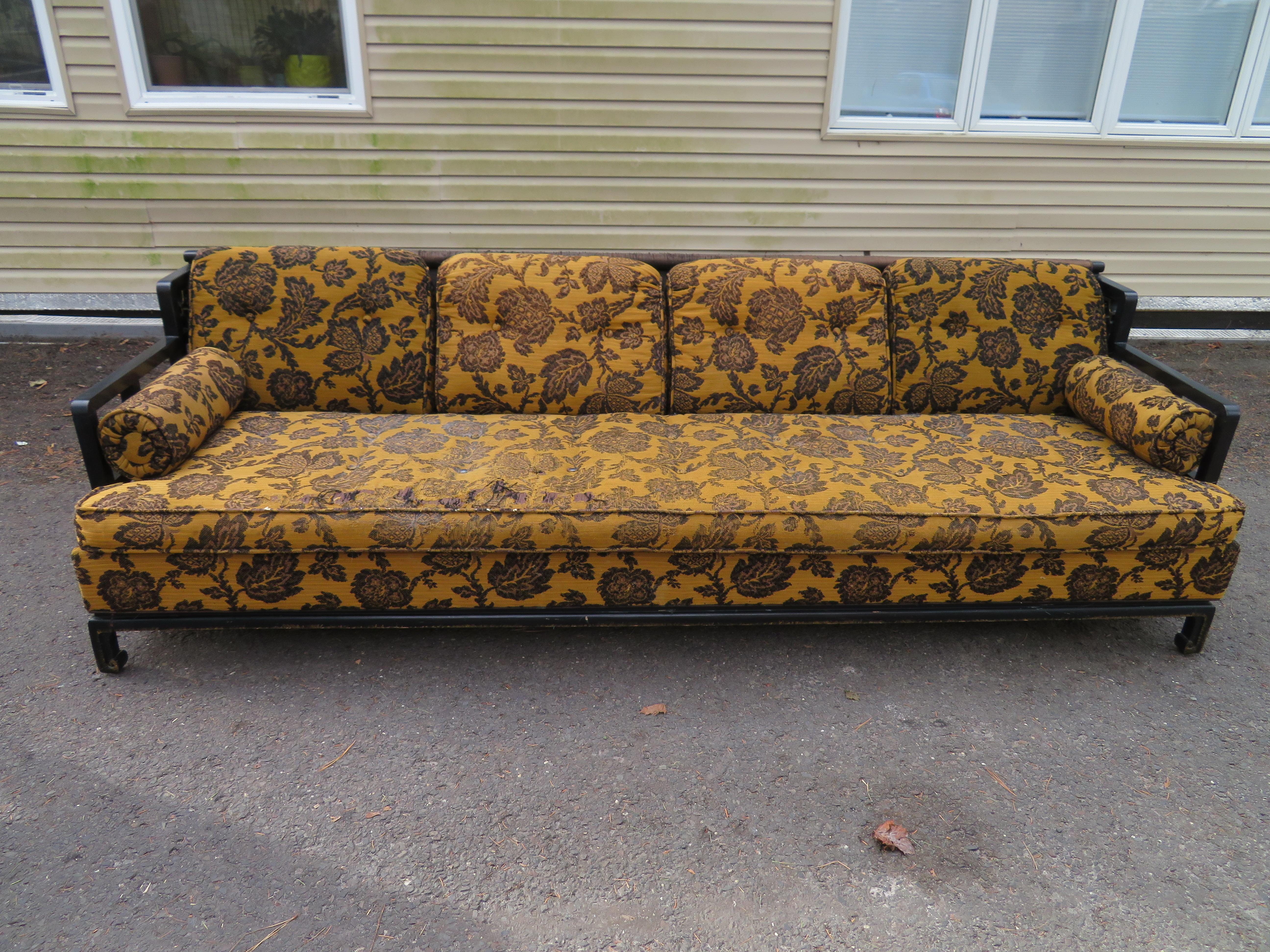 Asian James Mont style sofa with black painted wooden frame- open work design along the sides with gold painted details, circa 1970s. This wonderful sofa also has lovely Chow style legs with touches of gold paint. The original upholstery is dated