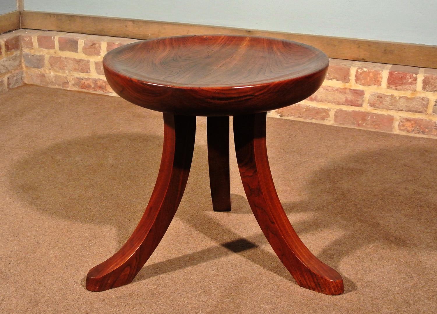 A very unusual Thebes style dished stool made from solid walnut and set on a curved tripod support.

Unmistakably Liberty but not stamped and not the usual Thebes design. 

Extremely heavy and with a fantastic color and figuring to the walnut