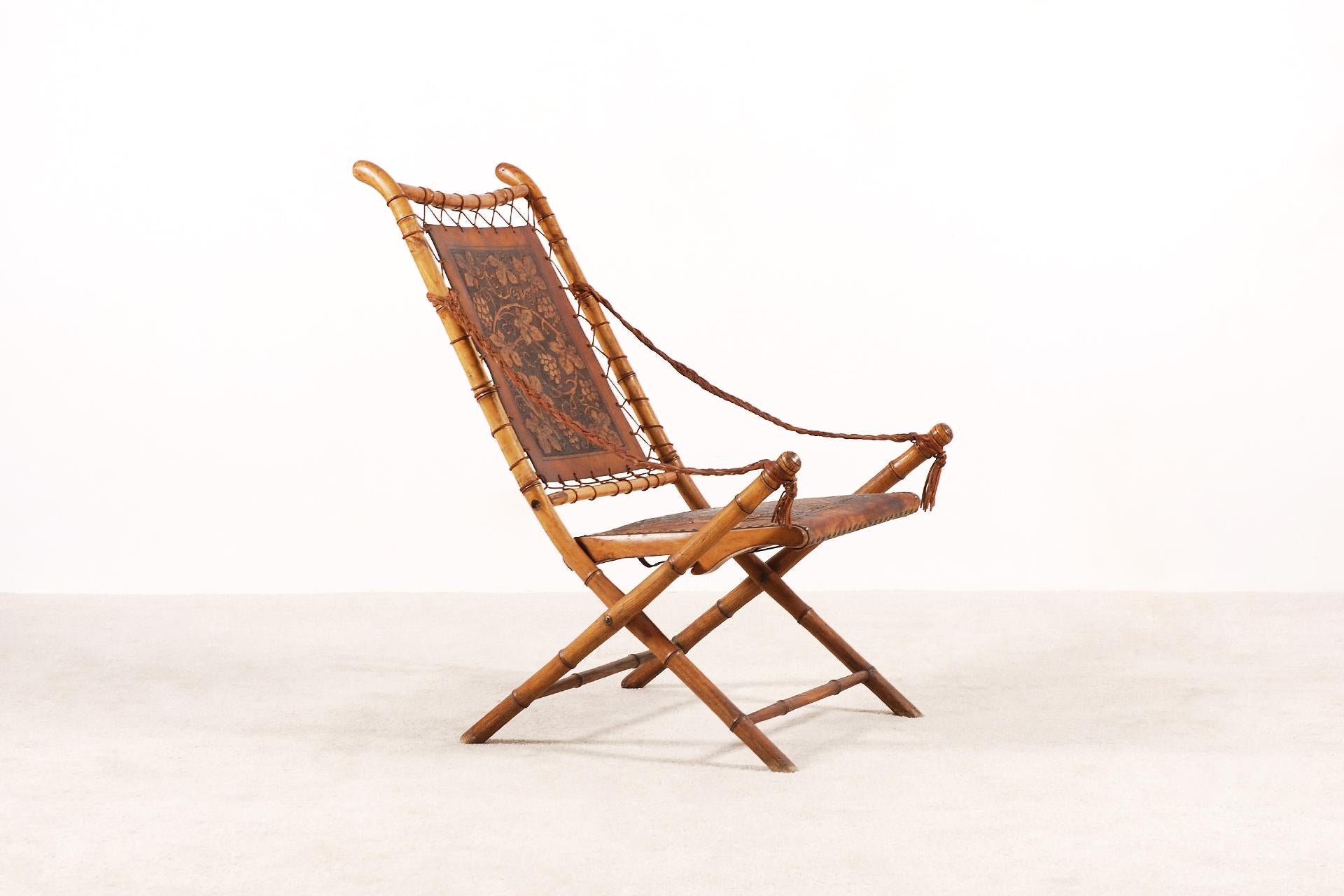 Unusual and unique folding chair, France, 19th century.
Oak wood structure imitating the bamboo. And extremely Fine hand-tooled leather work. Laced leather armrests.
Very decorative and ideal as a bedroom chair.
Very good condition, can be used