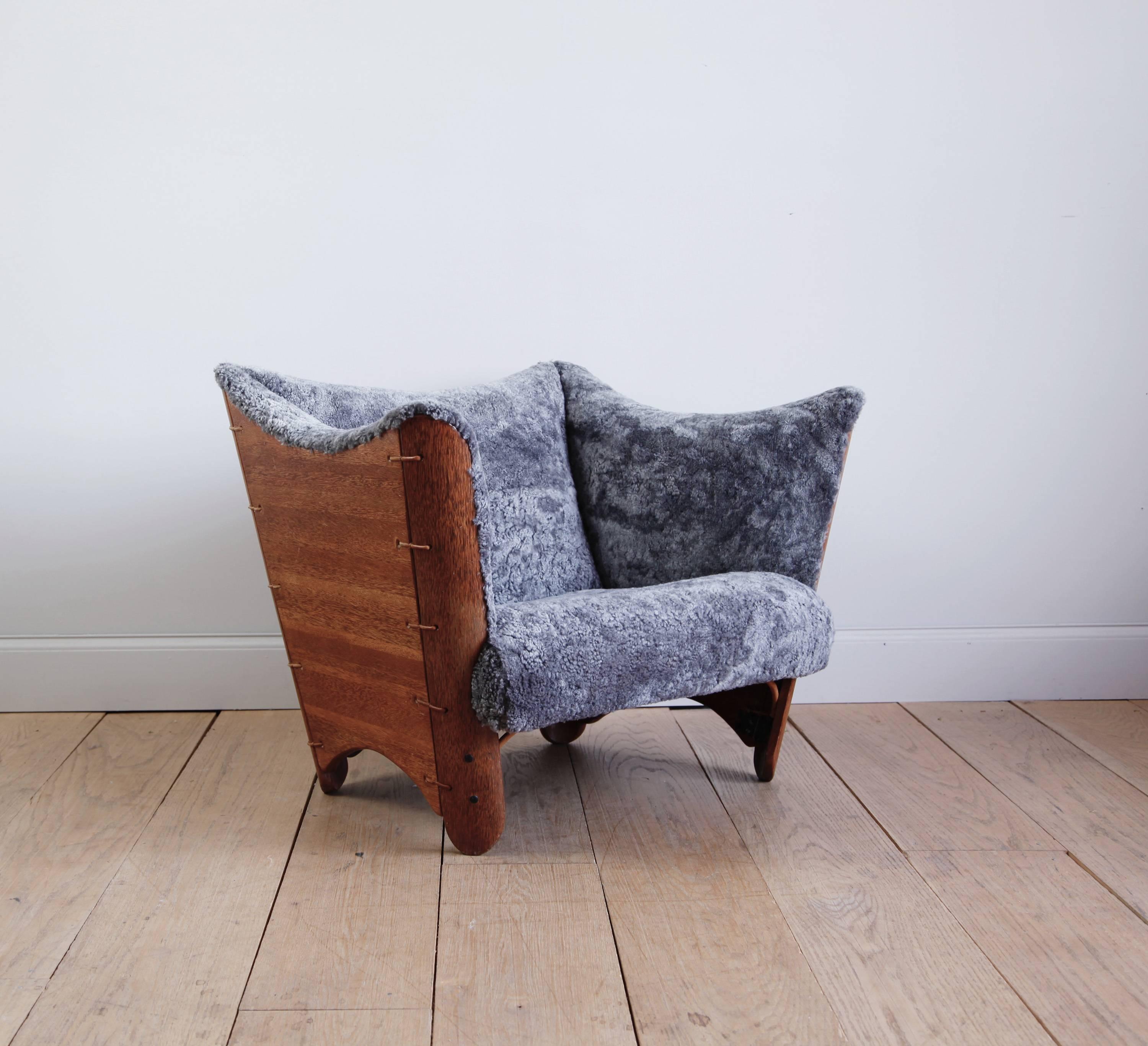 A deep and enveloping lounge chair, the frame made of palm wood and leather, the seat covered in a very soft Scandinavian shearling.

It has a commanding and sculptural presence.