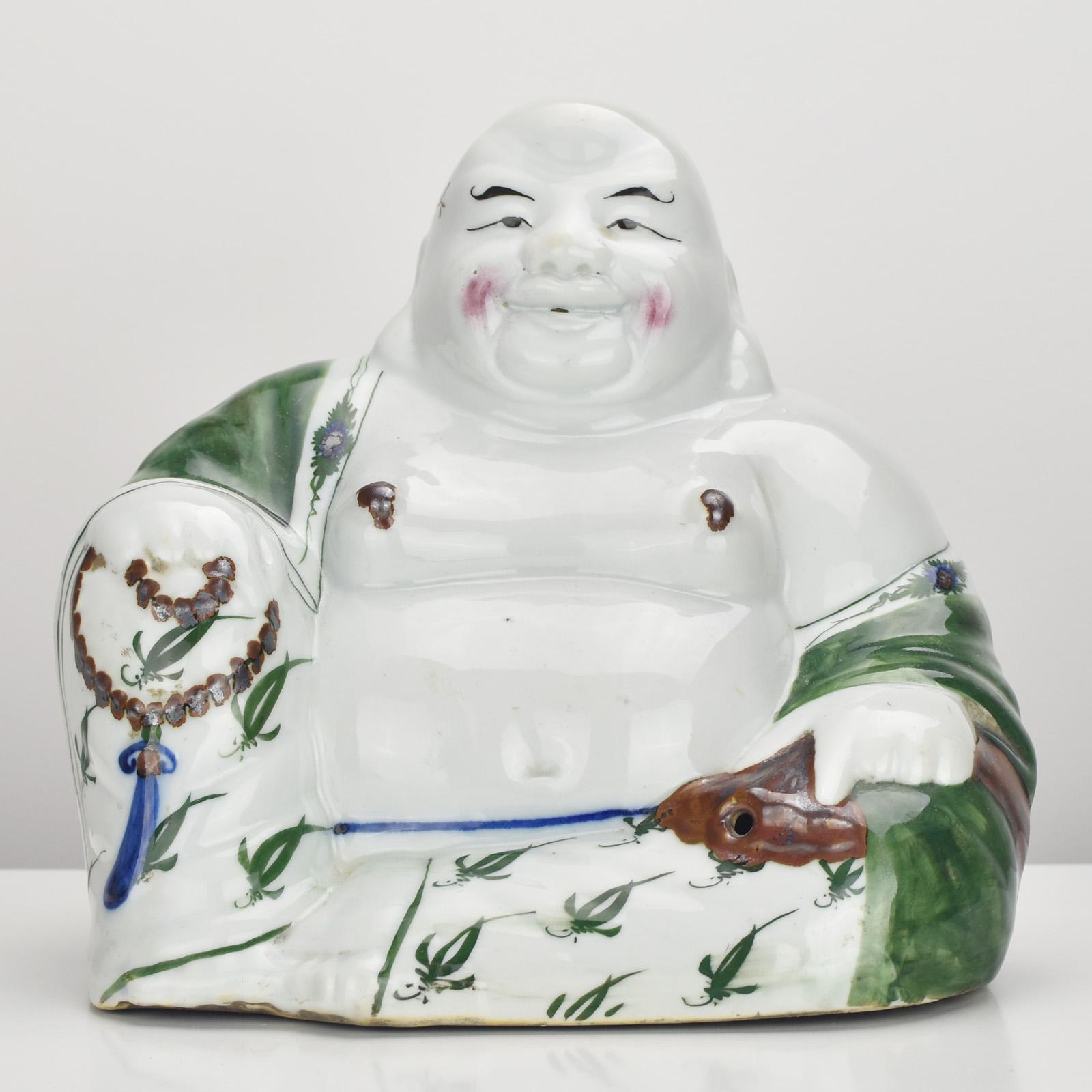 The unusual antique ca. 1920 Qing Chinese porcelain Laughing Buddha is a remarkable and exquisite piece of art that exudes charm and cultural significance. The statue features the iconic Laughing Buddha, also known as Budai or Hotei, a beloved