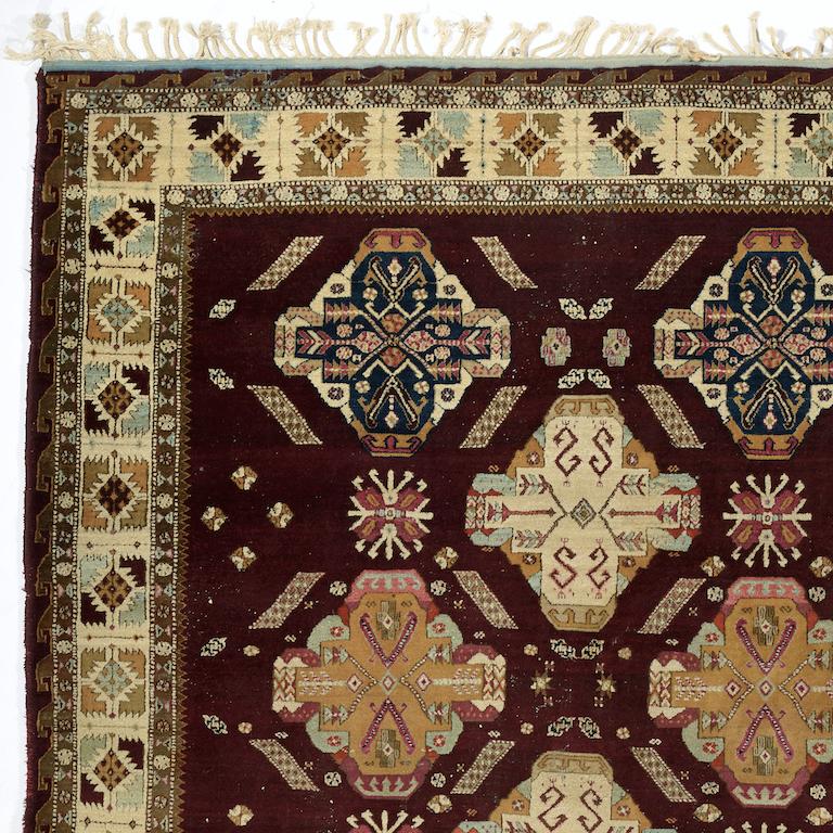 A highly unusual Agra carpet with stylised Caucasian design, on a rich burgundy red background.
