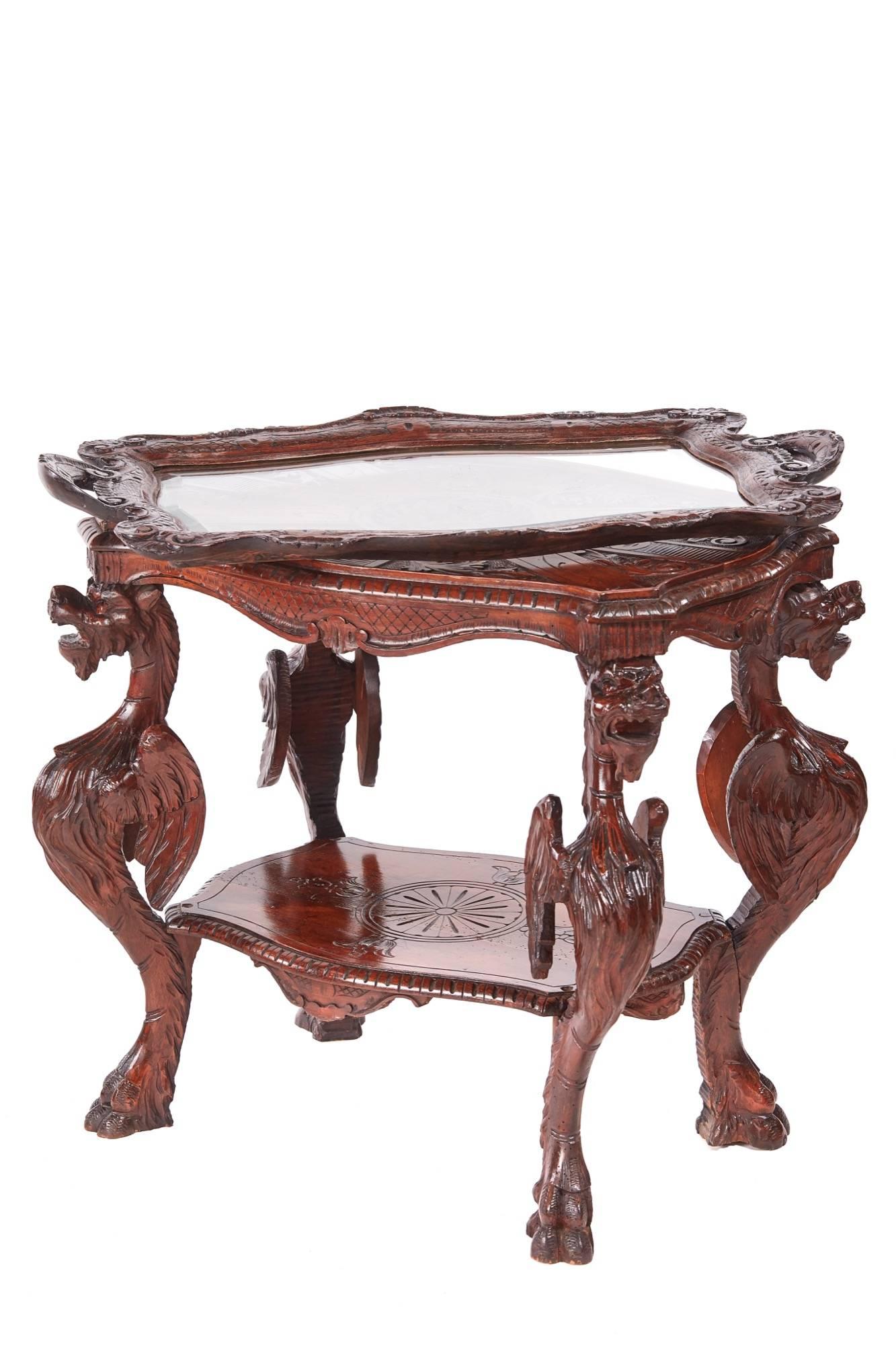 Unusual antique carved oak Italian centre table, having a serpentine carved top with lion decoration, fitted with a removable tray with a glass top, the upper tier raised on four lovely carved caryatid dragon legs on paw feet united by a carved