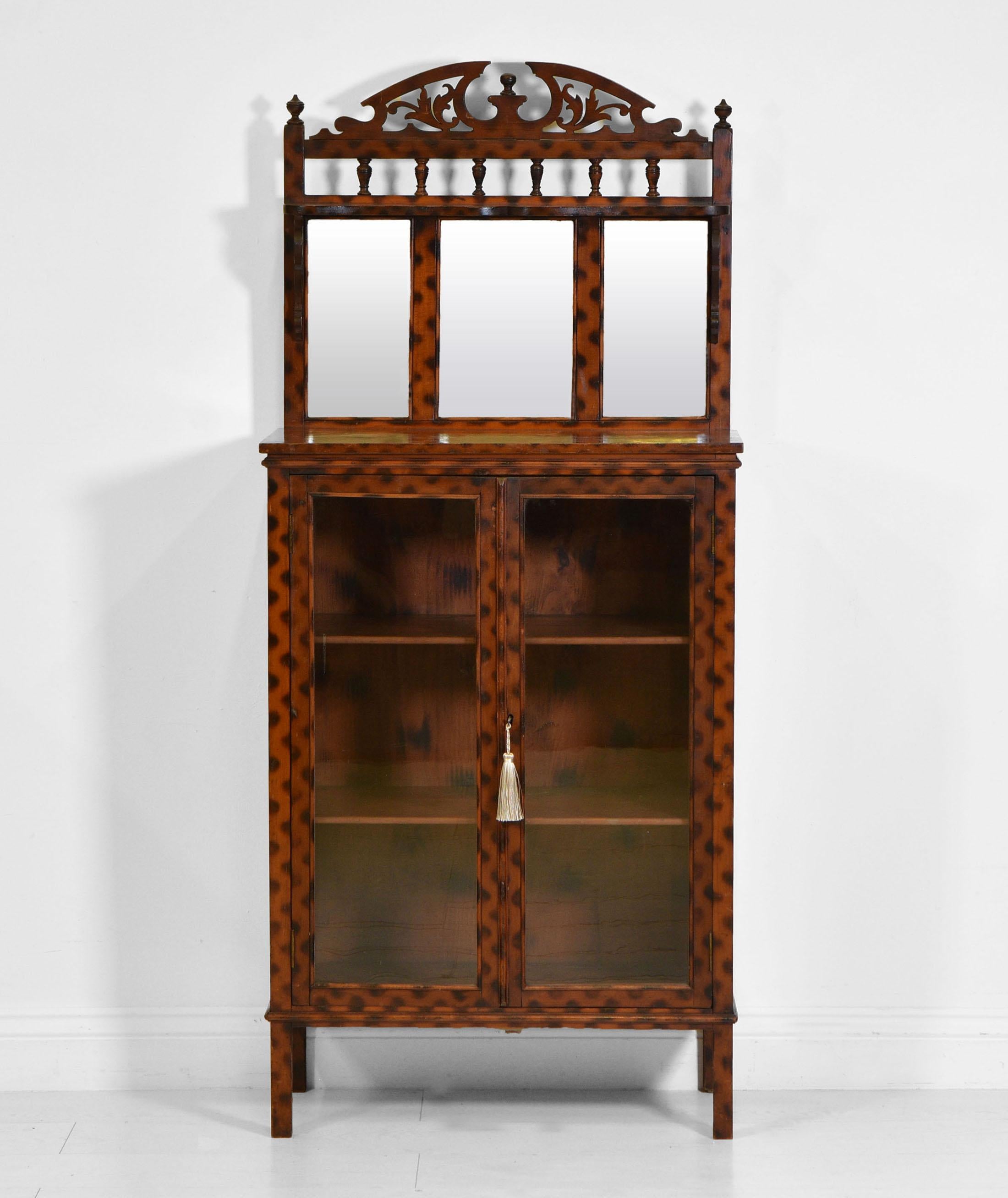 An unusual and quite rare Edwardian antique bookcase cabinet with the original burnt patterned finish. Circa 1900.

The original finish to this decorative cabinet does have a slightly distressed patina in places, expected with age. It has been
