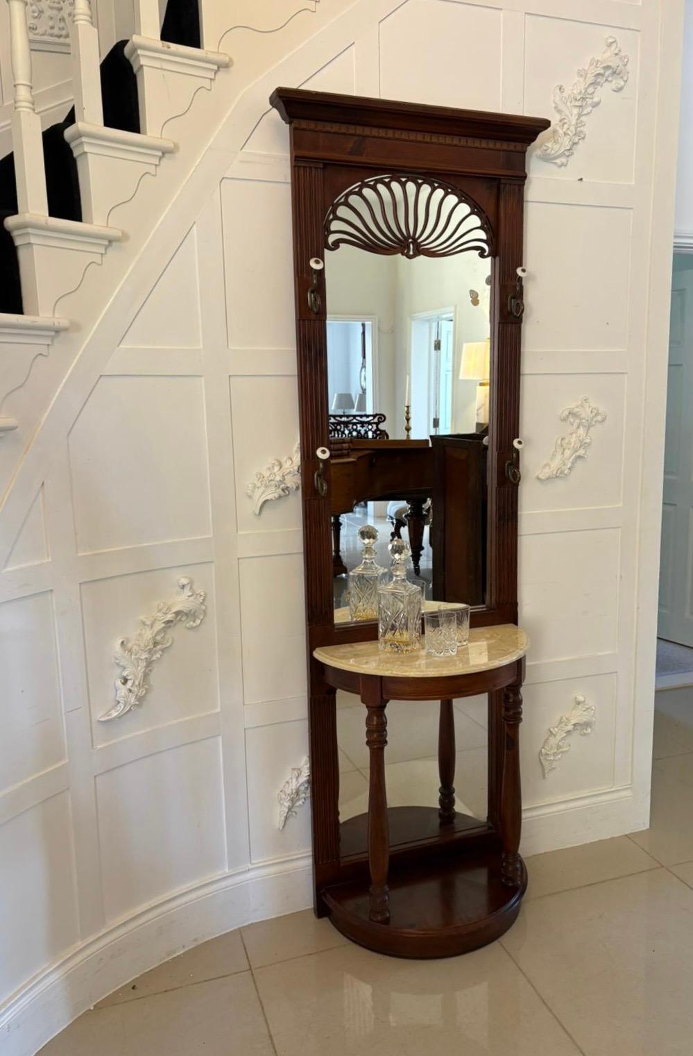 Unusual antique Edwardian quality walnut hall stand having the original mirror back with a quality pierced carving, 4 original coat/hat hooks above a demi lune shaped marble top supported by turned columns, mirror back standing on a walnut plinth