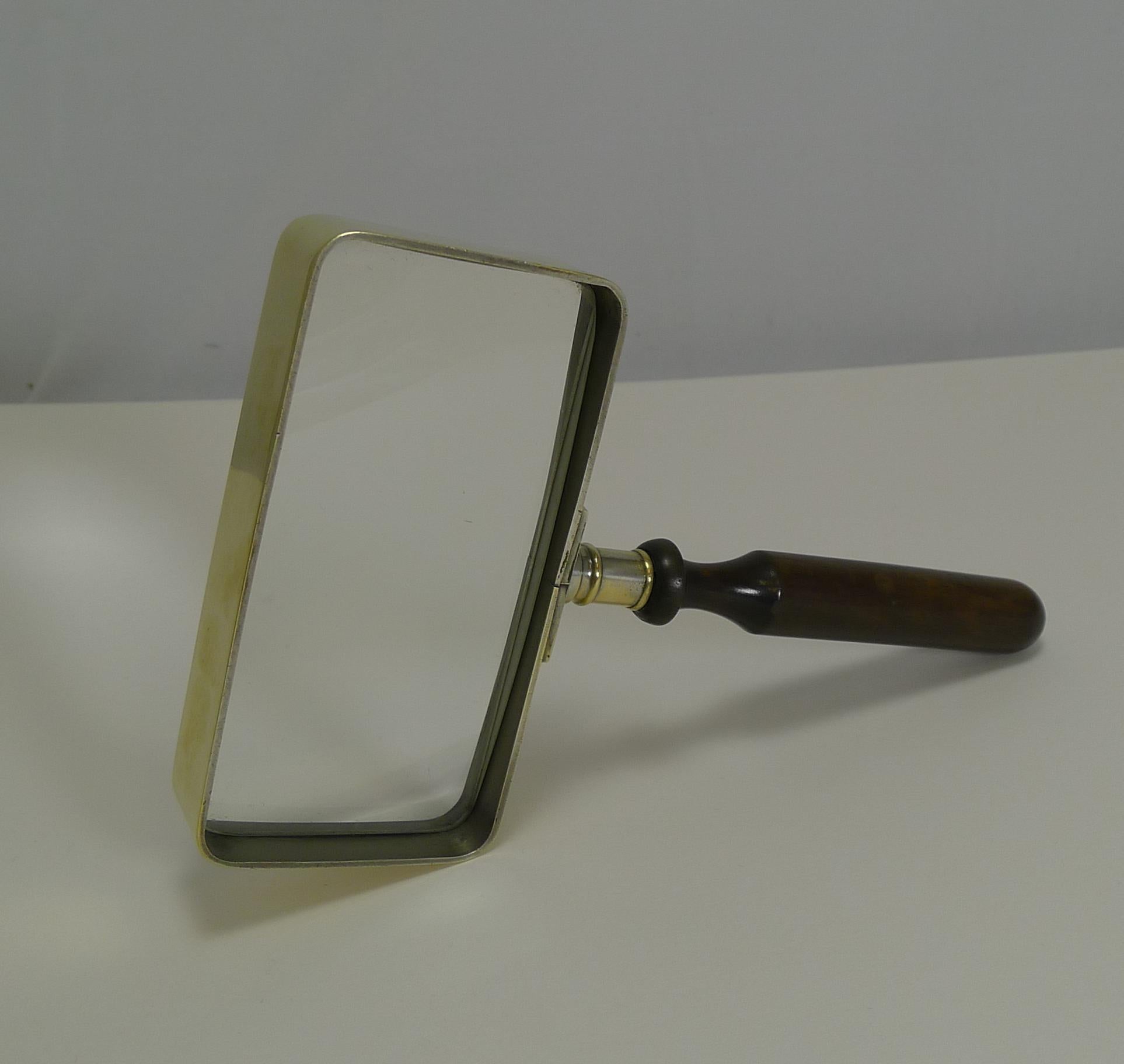 A handsome Edwardian brass framed rectangular magnifying glass professionally polished to gleam. The handle is made form turned ebony wood.

Dating to circa1900, the glass is in excellent condition with a good strong magnification. Measures: 4