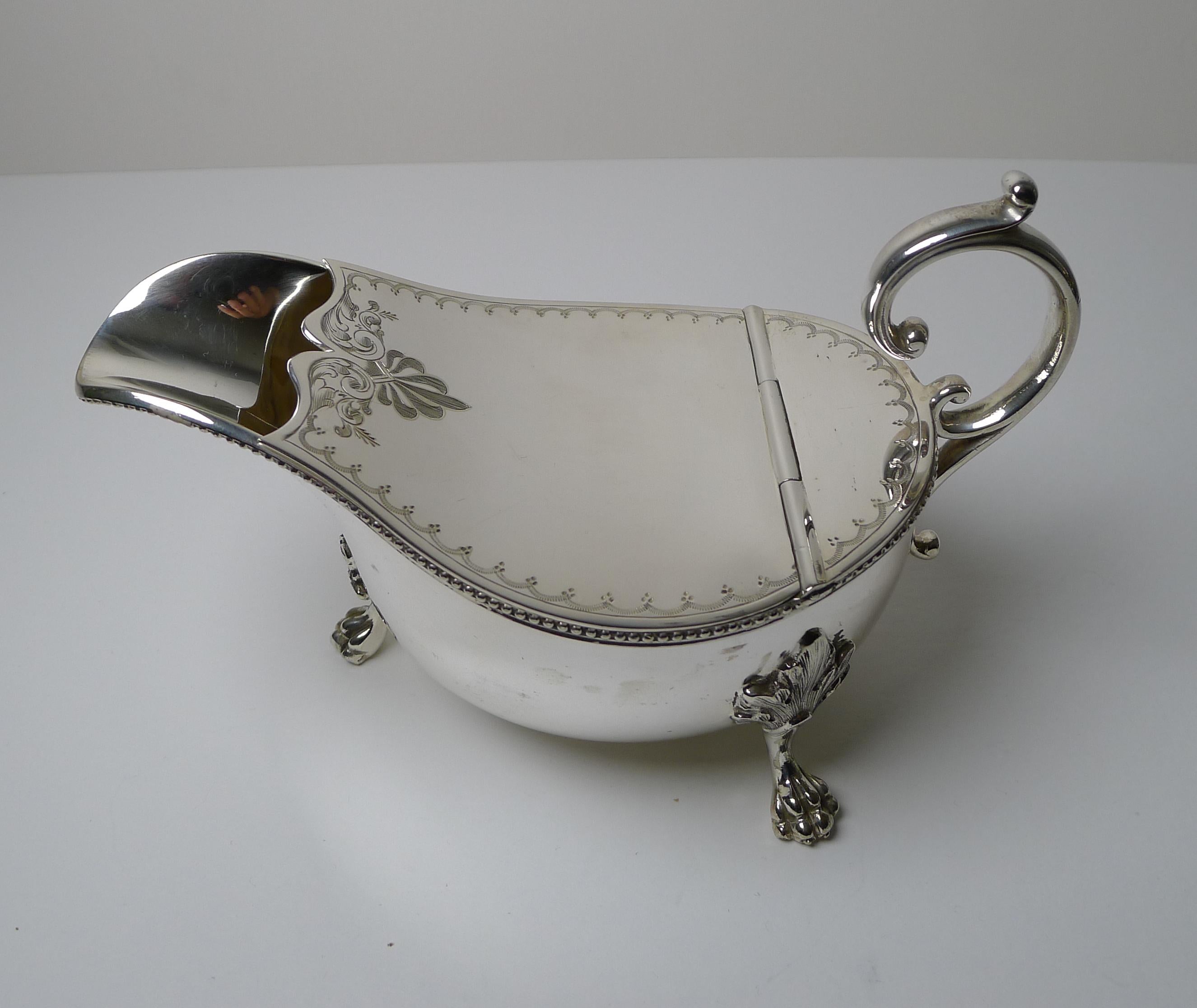 A most unusual Victorian novelty spoon warmer in the form of a sauce or gravy boat.

The warmer stands on three handsome legs leading down to Lion's paw feet.

The hinged lid is beautifully engraved and the rim with a traditional beaded edge,