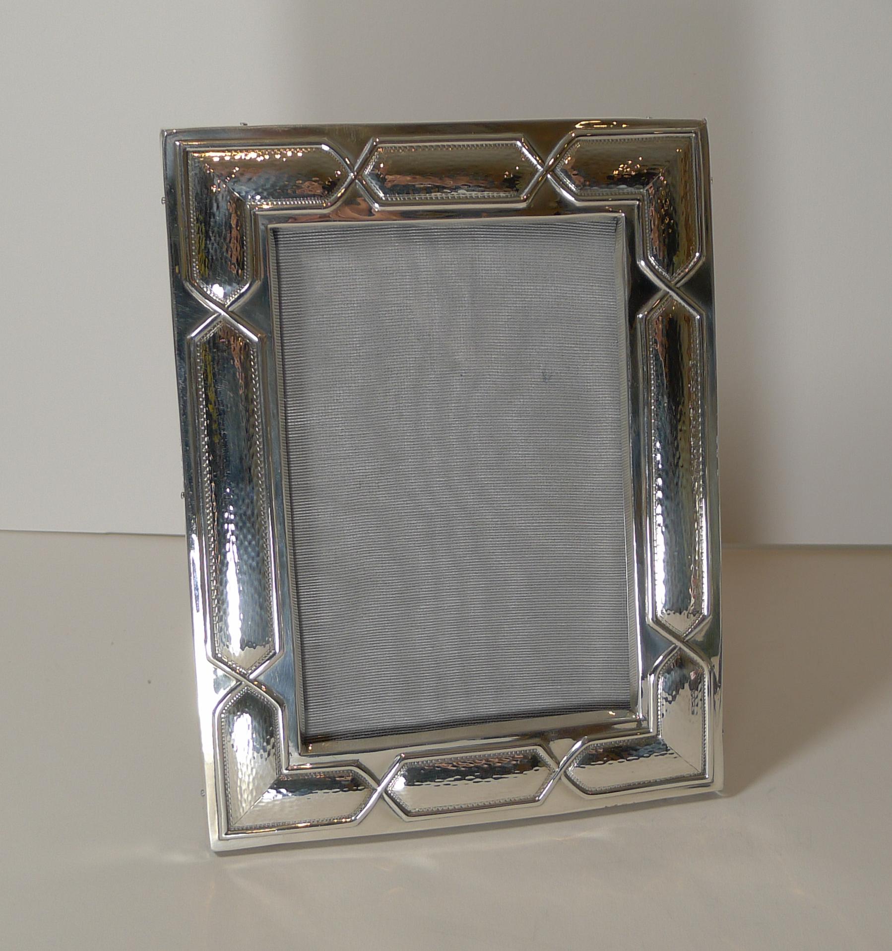 A magnificent and rare (I have never seen this design before) sterling silver photograph frame with a beautiful geometric (almost Celtic) design.

The backing is made from solid English Oak with a two-way folding easel stand allowing for the frame