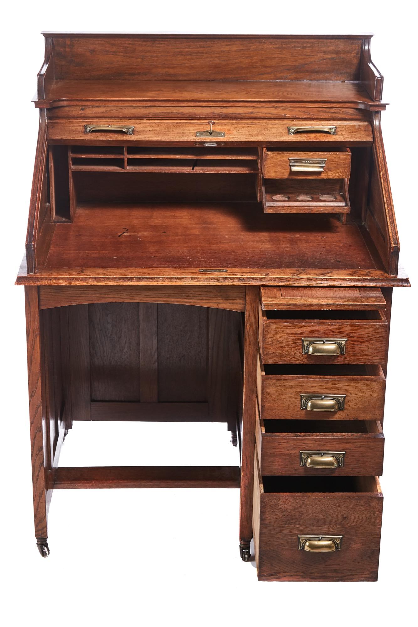 Unusual antique freestanding oak roll top desk with a lovely roll top fitted interior 4 drawers below with original handles, panelled sides and back. Standing on original castors.
Lovely color and condition.
Measures: 36