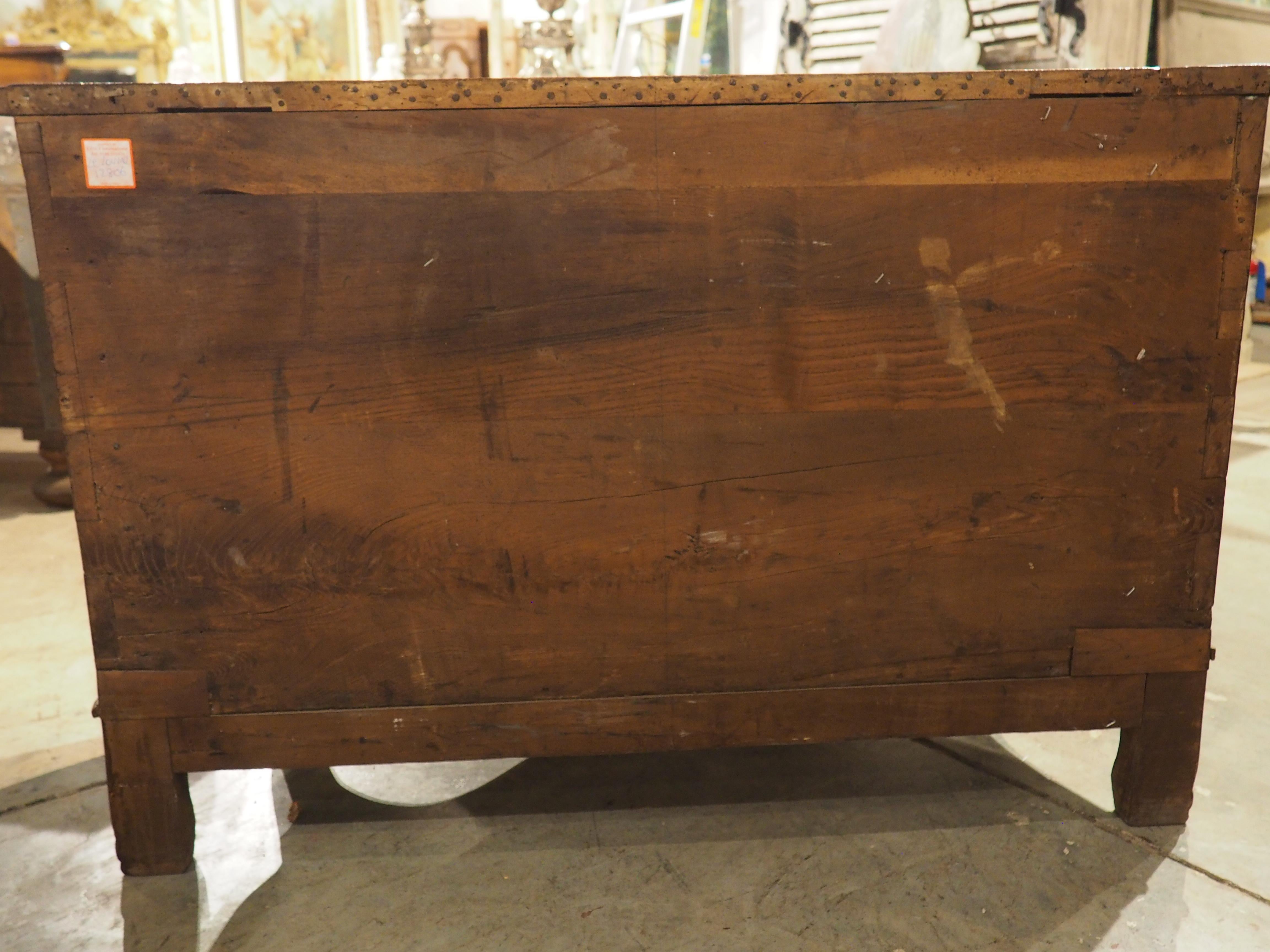 Questa insolita toilette a due cassetti in legno di noce con tiranti in ferro, proveniente dalla Francia, emana charme. Intagliata a mano in legno di noce nel 1800, la cassettiera ha una forma sinuosa. Il grembiule anteriore in arbalete, ornato da
