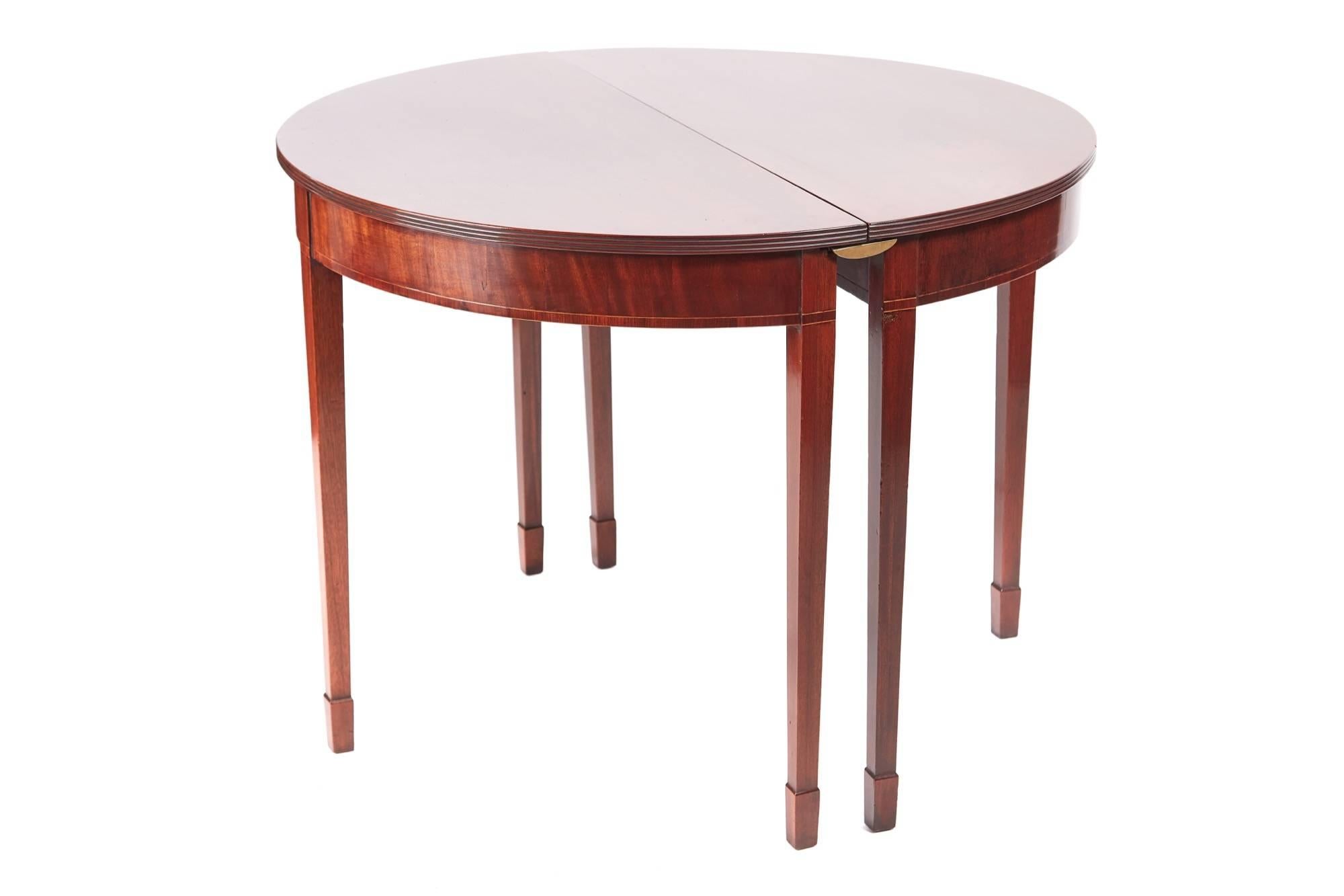 Unusual antique George III mahogany dining table, having a fantastic solid mahogany top with a reeded edge, lovely inlaid frieze, one extra leaf, standing on square tapering legs with spade feet
This table makes a round centre table
and a pair of