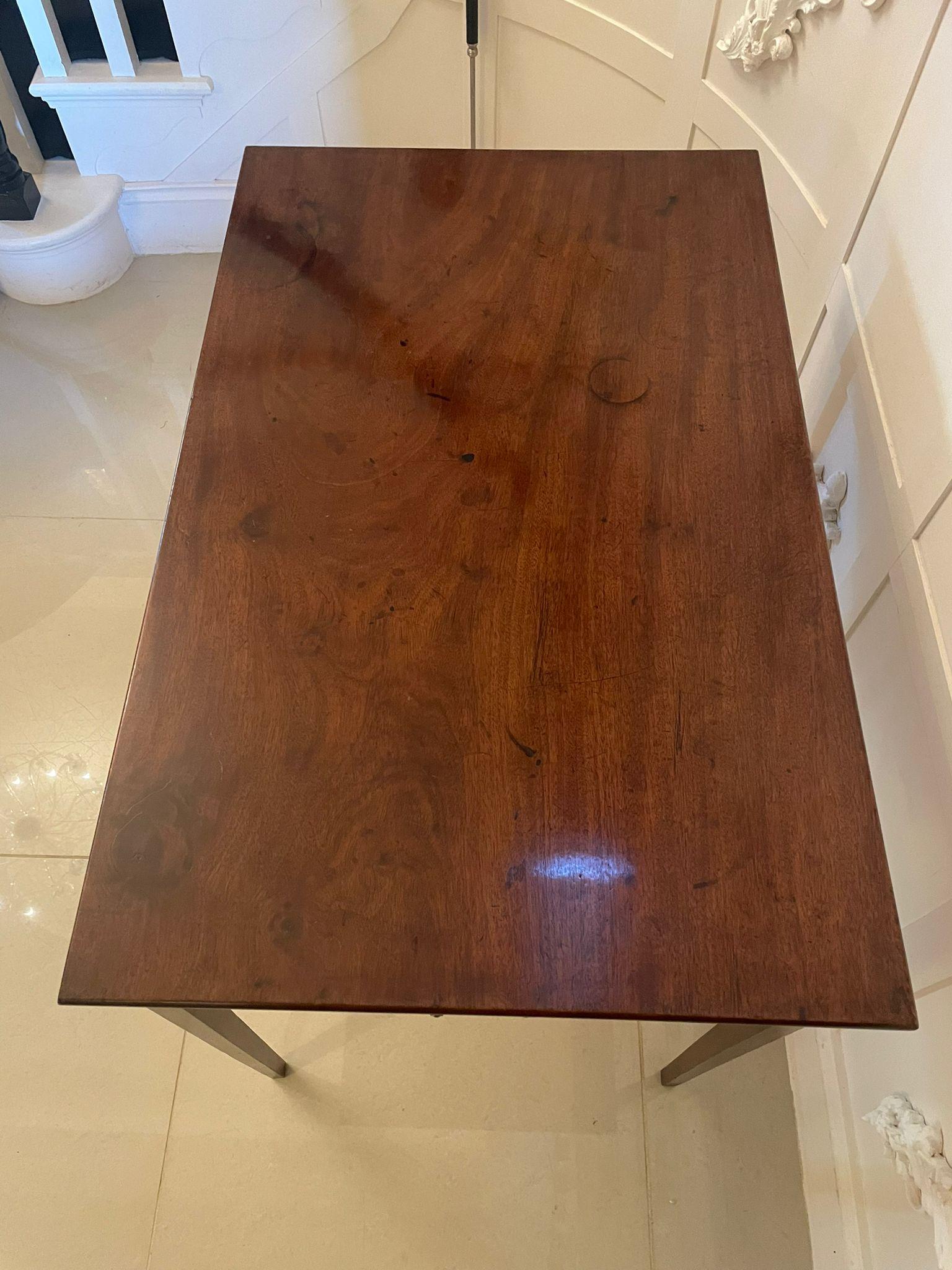 Table d'appoint inhabituelle en acajou de qualité George III, avec un plateau en acajou de qualité, un bord mouluré, un tiroir de chaque côté avec des poignées ovales en laiton d'origine et reposant sur des pieds carrés effilés.

H 74cm 
W 86.5cm