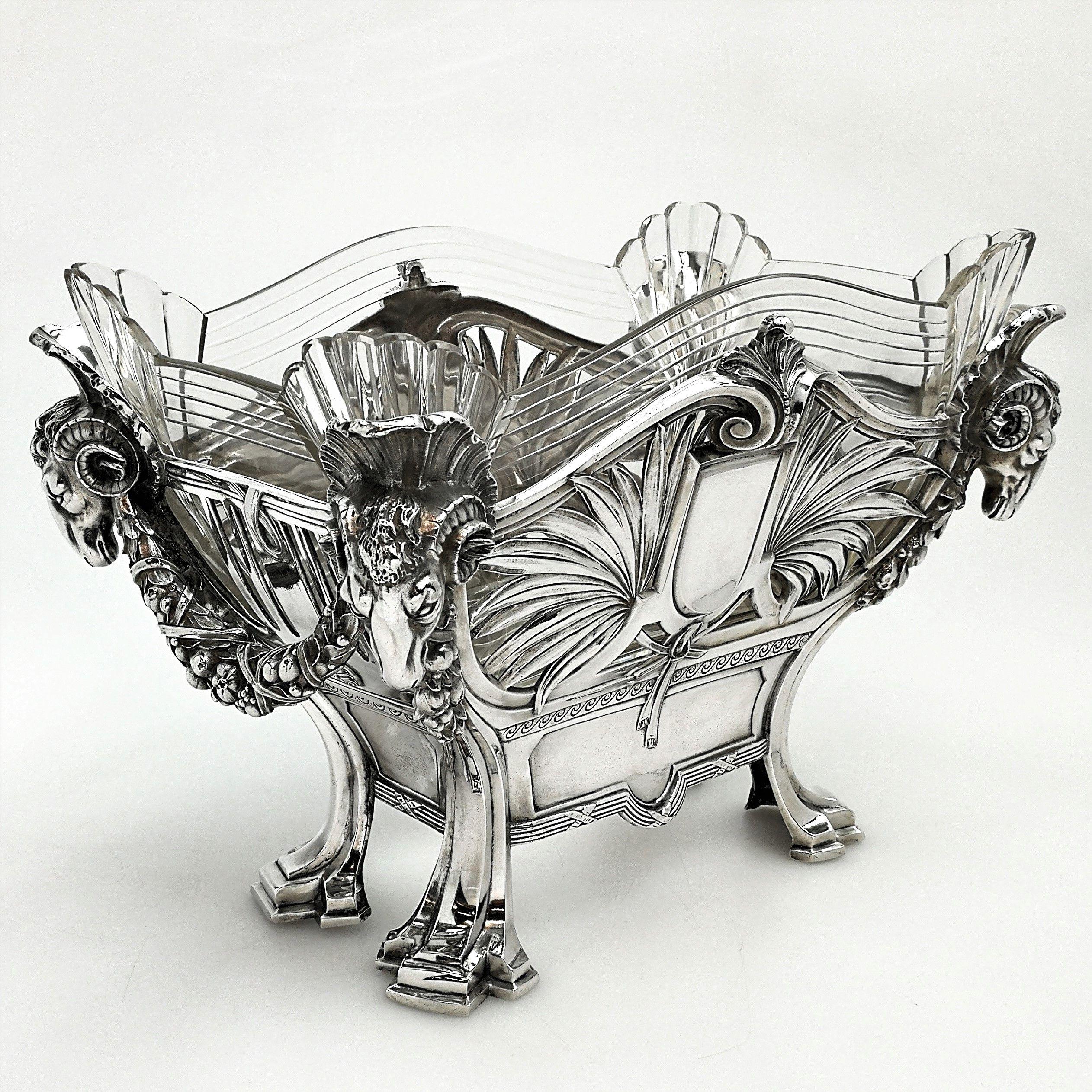 A magnificent antique German solid silver bowl or jardinière with a gorgeous clear glass liner. The four corners of the silver body feature impressive Rams heads connecting cast silver swags across the shorter sides of the dish. The longer sides of