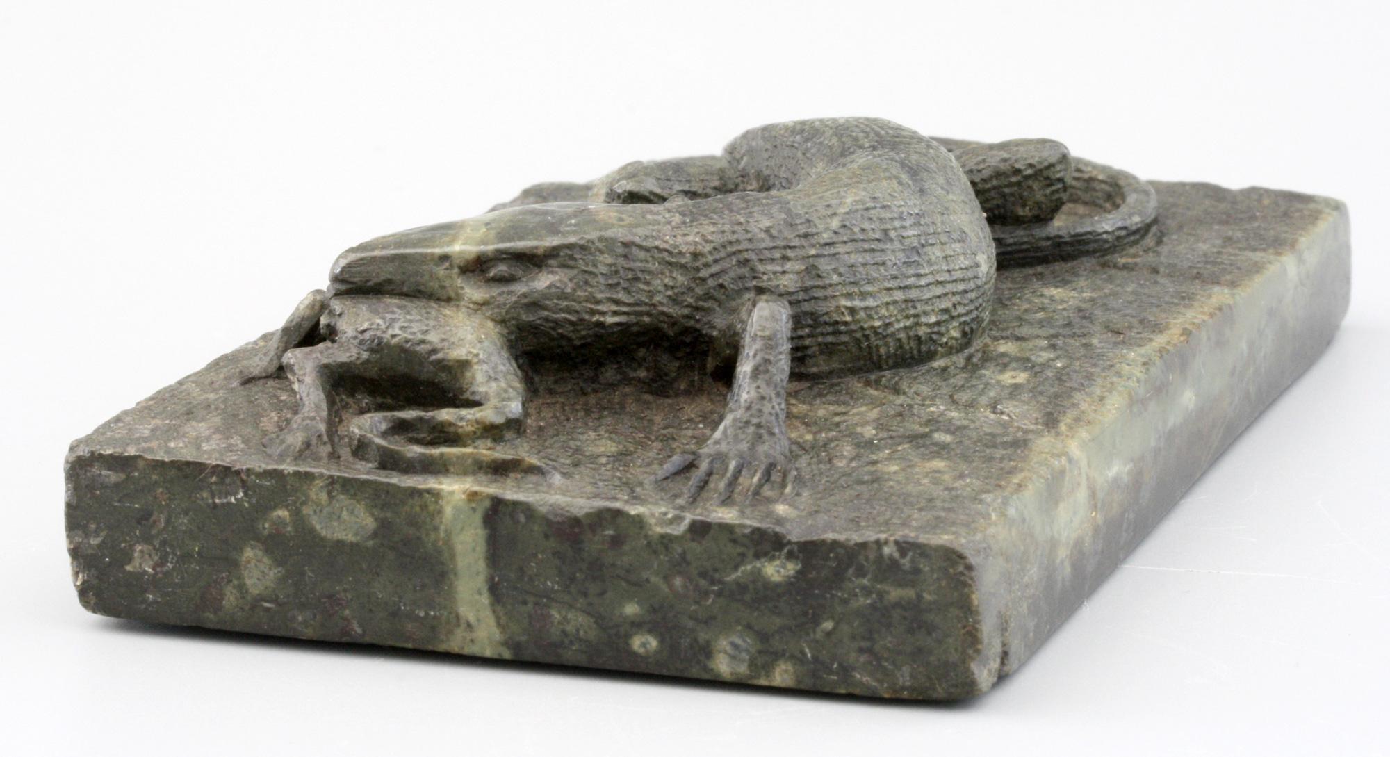 A superb antique carved stone sculptural desk weight modeled as a lizard with its prey dating from the 19th century. Carved from a single piece of rectangular shaped stone the lizard is carved holding its prey in its mouth and stands on a flat
