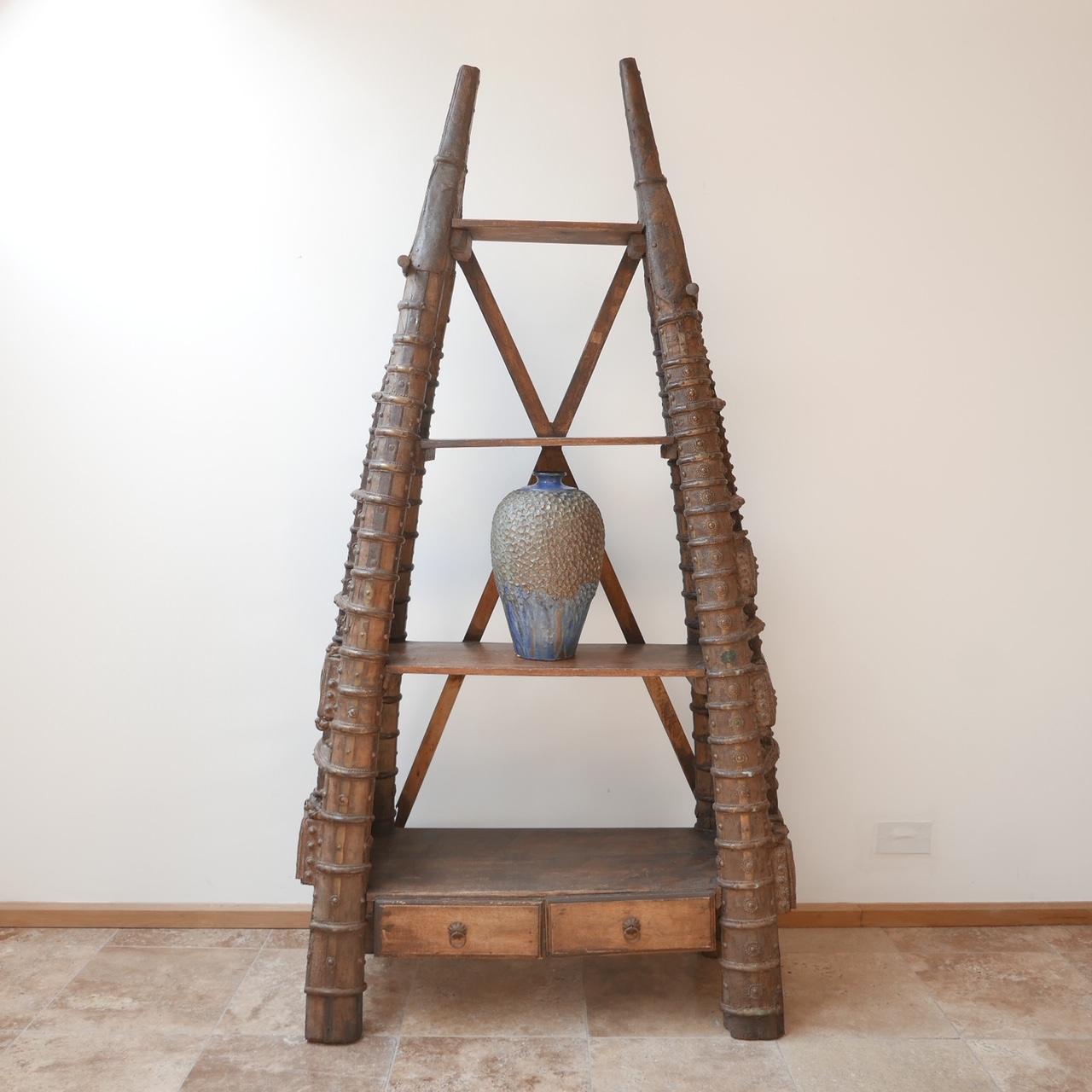 A unique and unusual shelving composition.

Believed to be early 20th century possibly earlier. 

Formed from heavy wood, with a variety of metal and brass embellishments. 

Found in France, likely African or Indian origin

Ideal as a