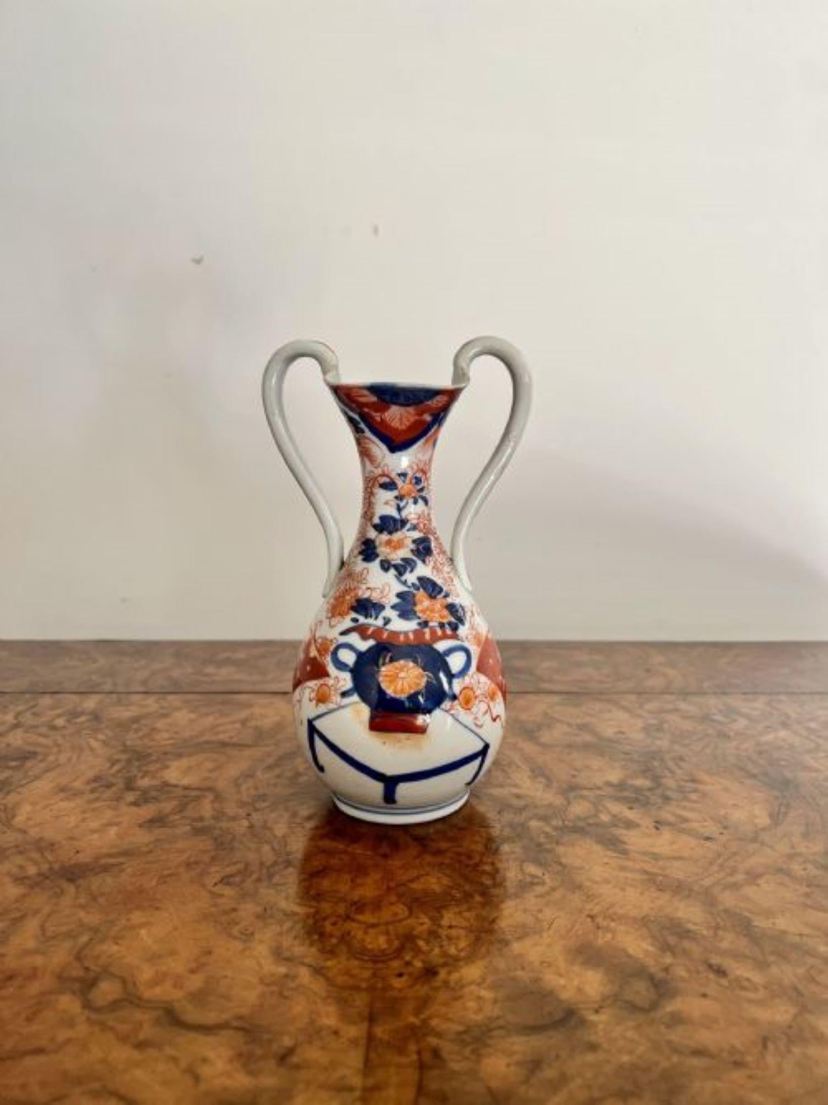 Unusual antique Japanese quality imari vase having shaped twin handles to the sides, lovely shaped body with a fluted neck with wonderful hand painted panels in red, blue, orange and white colours.