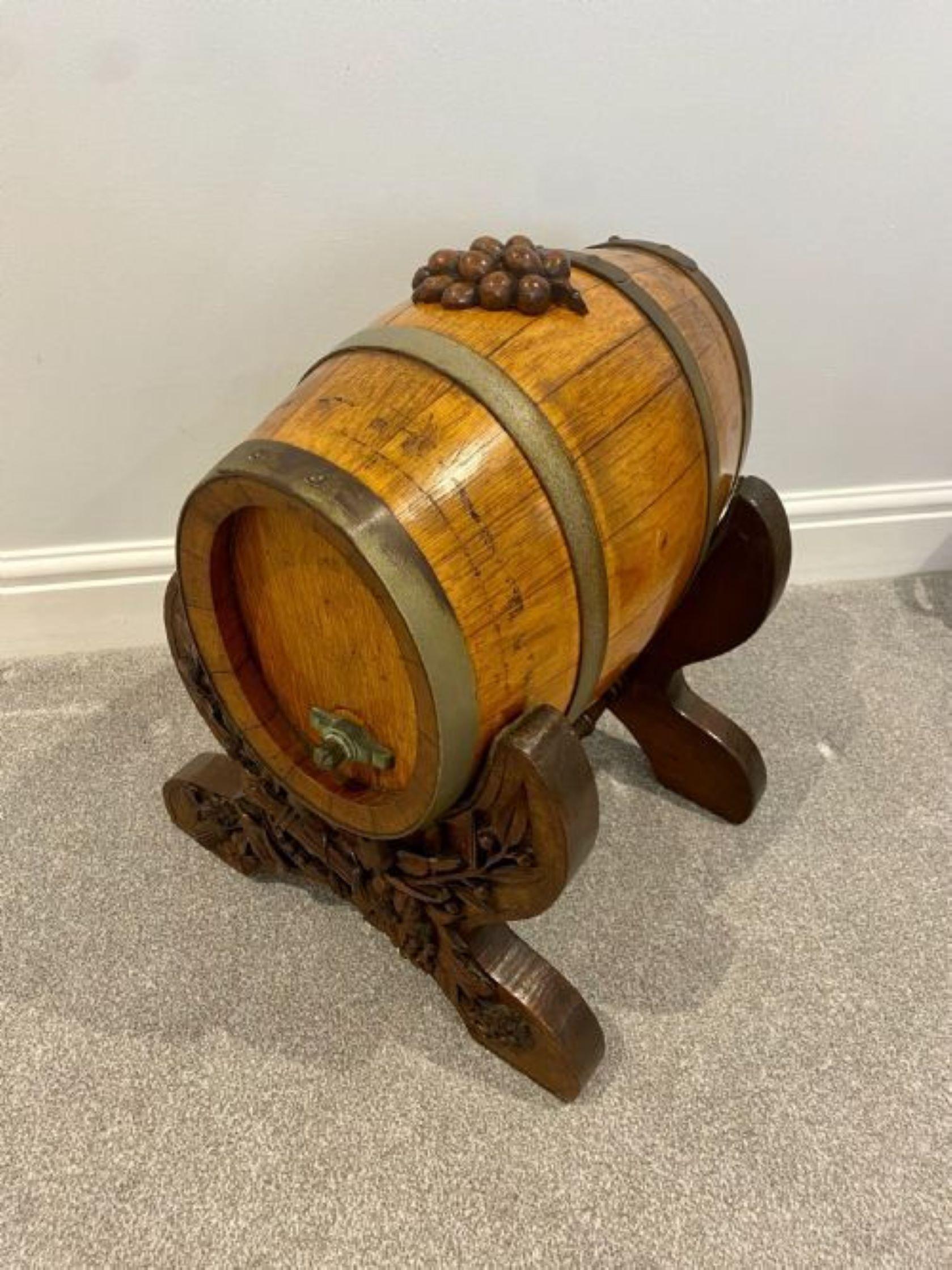 Unusual antique oak brass bound barrel on a quality black forest stand having a quality oak barrel with four brass bounds and a carved top, carved removable grapes on a quality Black Forest shaped stand united by a turned stretcher 
