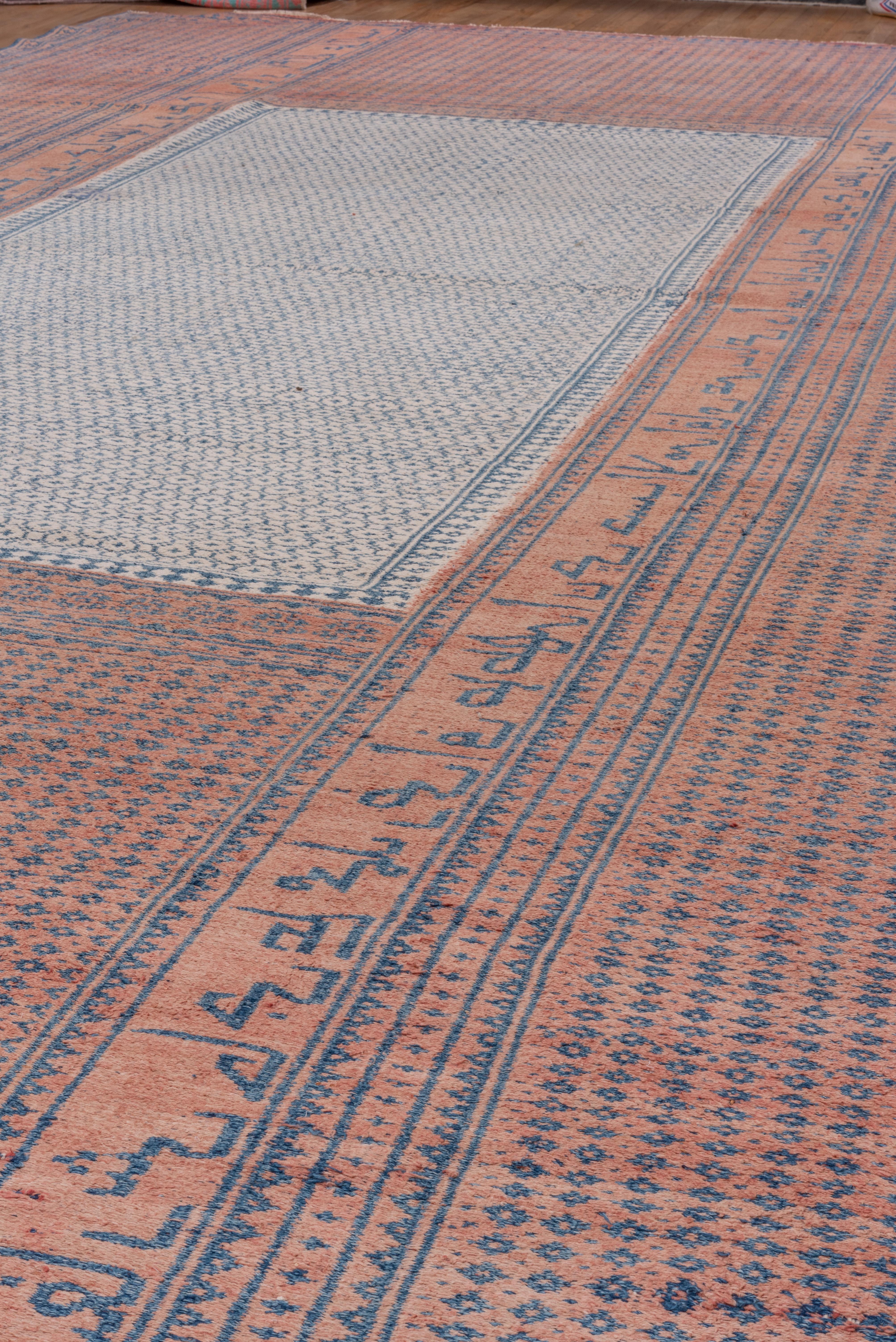 Dans une technique de trame supplémentaire, ce tapis bleu et rose présente une inscription poétique angulaire qui court sur les côtés de la bordure. Tissage lourd, construction entièrement en laine.